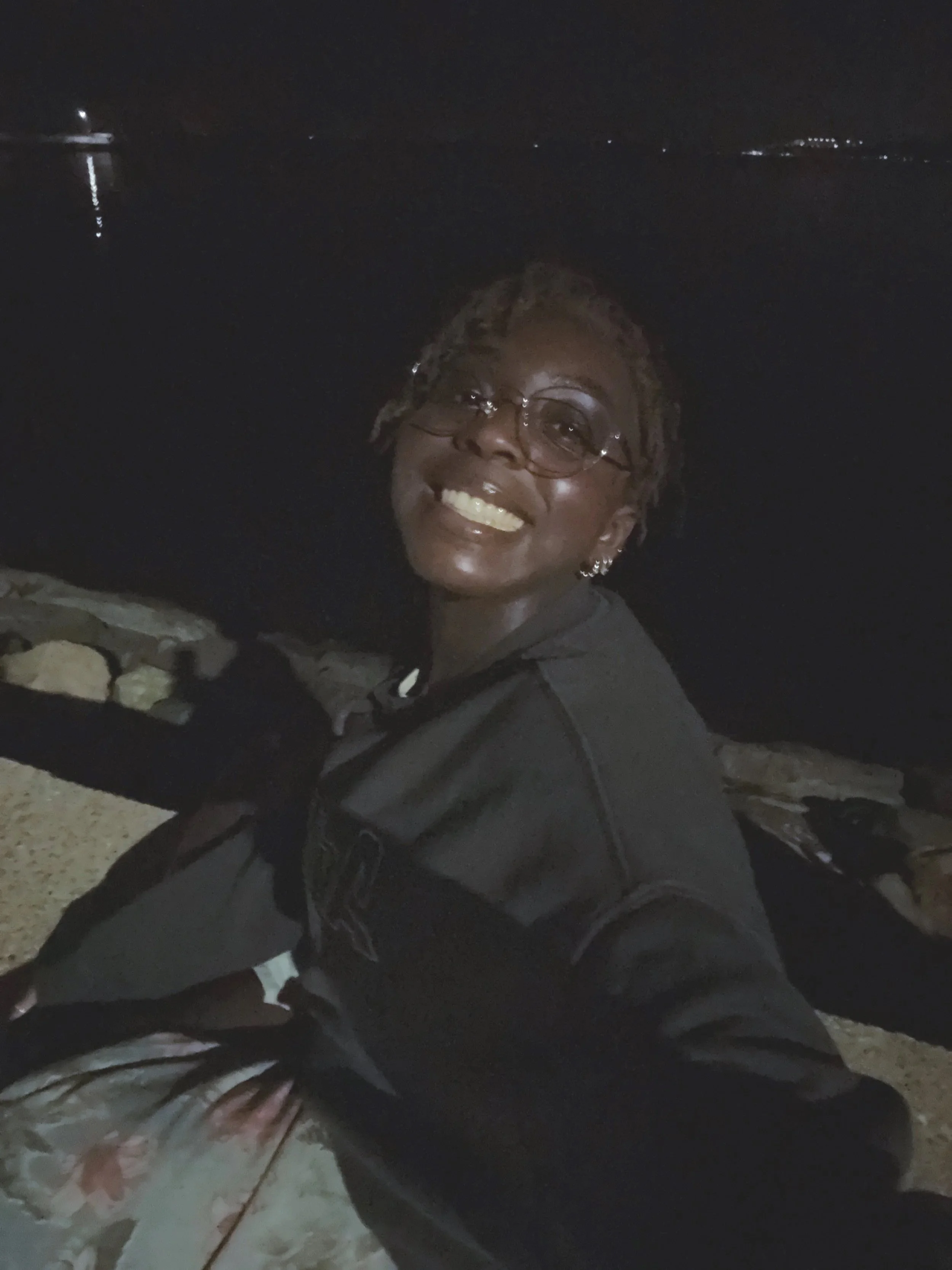 A person smiling while sitting on a wall