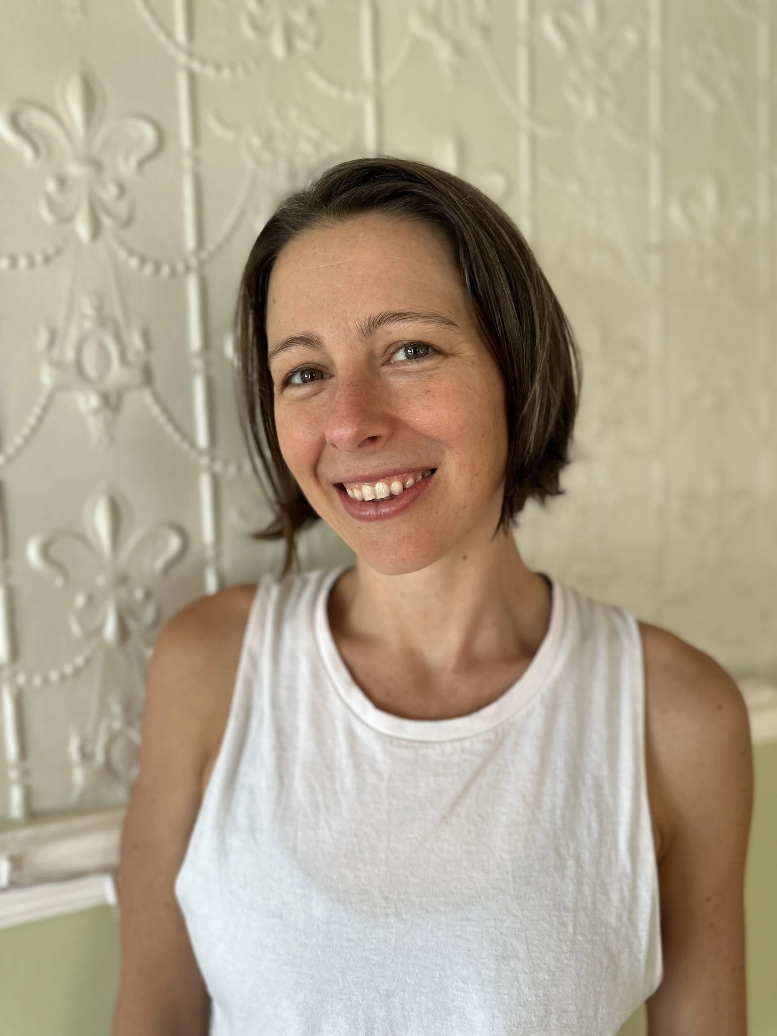 Julia Janczur yoga teacher smiling wearing a white shirt.