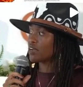 Person with microphone wearing a wide-brimmed hat