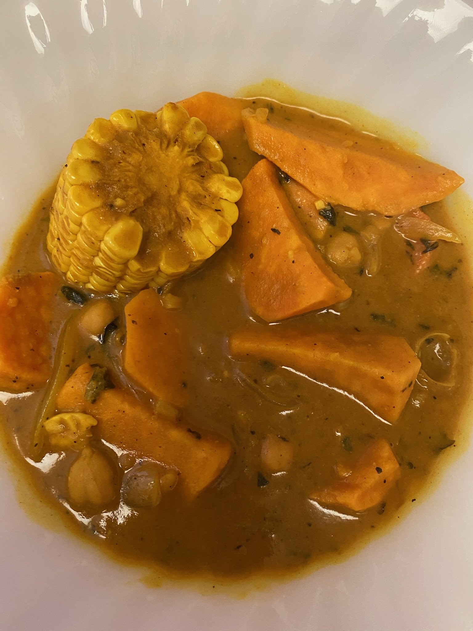 Bowl of stew with corn, sweet potatoes, and spices