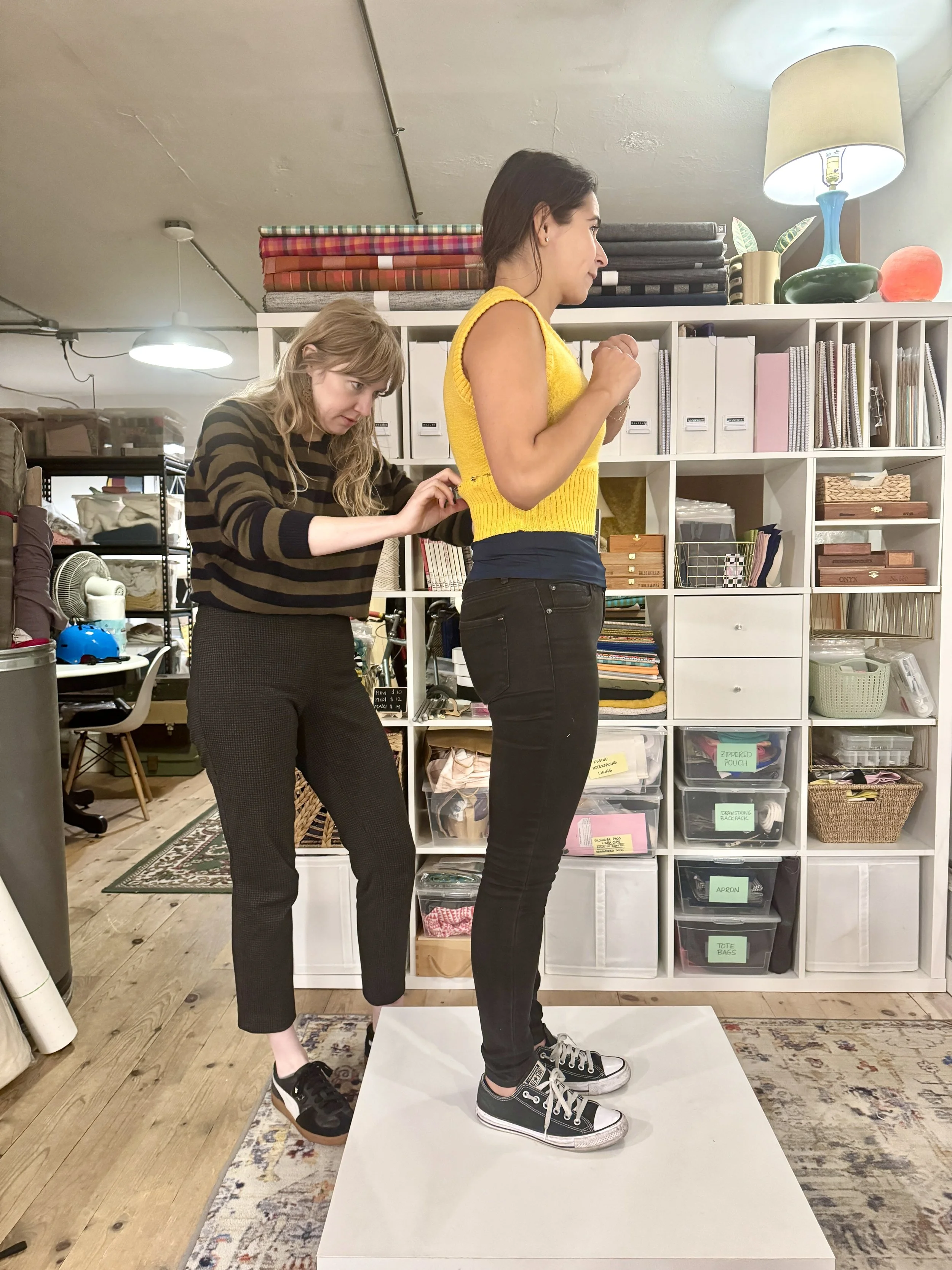jade doing a fitting on a yellow knit tank from first kiss tattoos and vintage