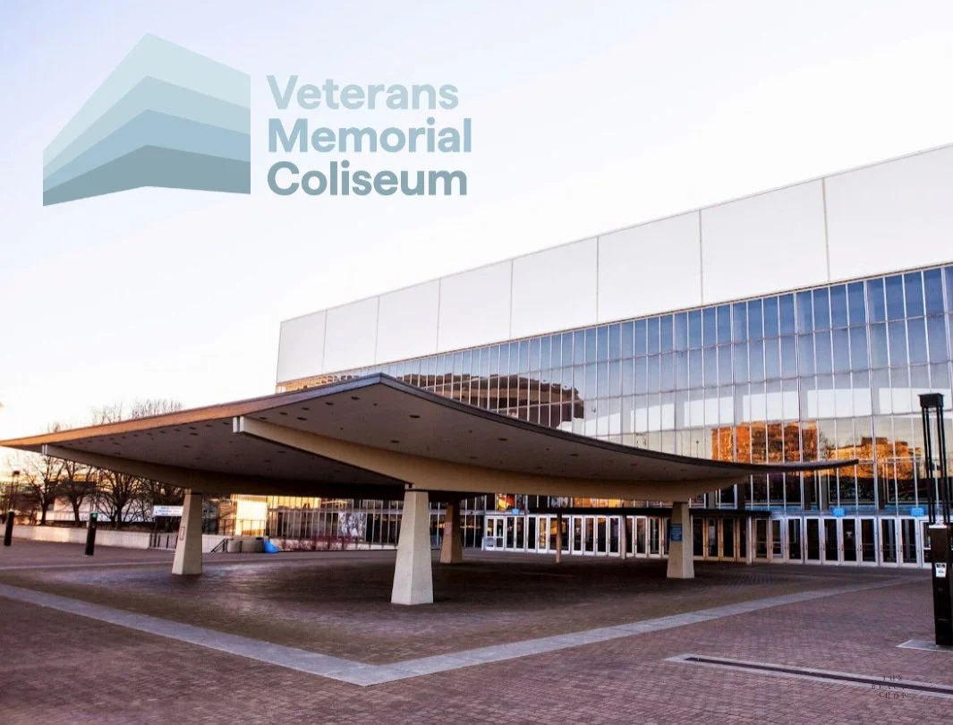 Exterior of the Veterans Memorial Coliseum building with a modern architectural design and a large glass facade.