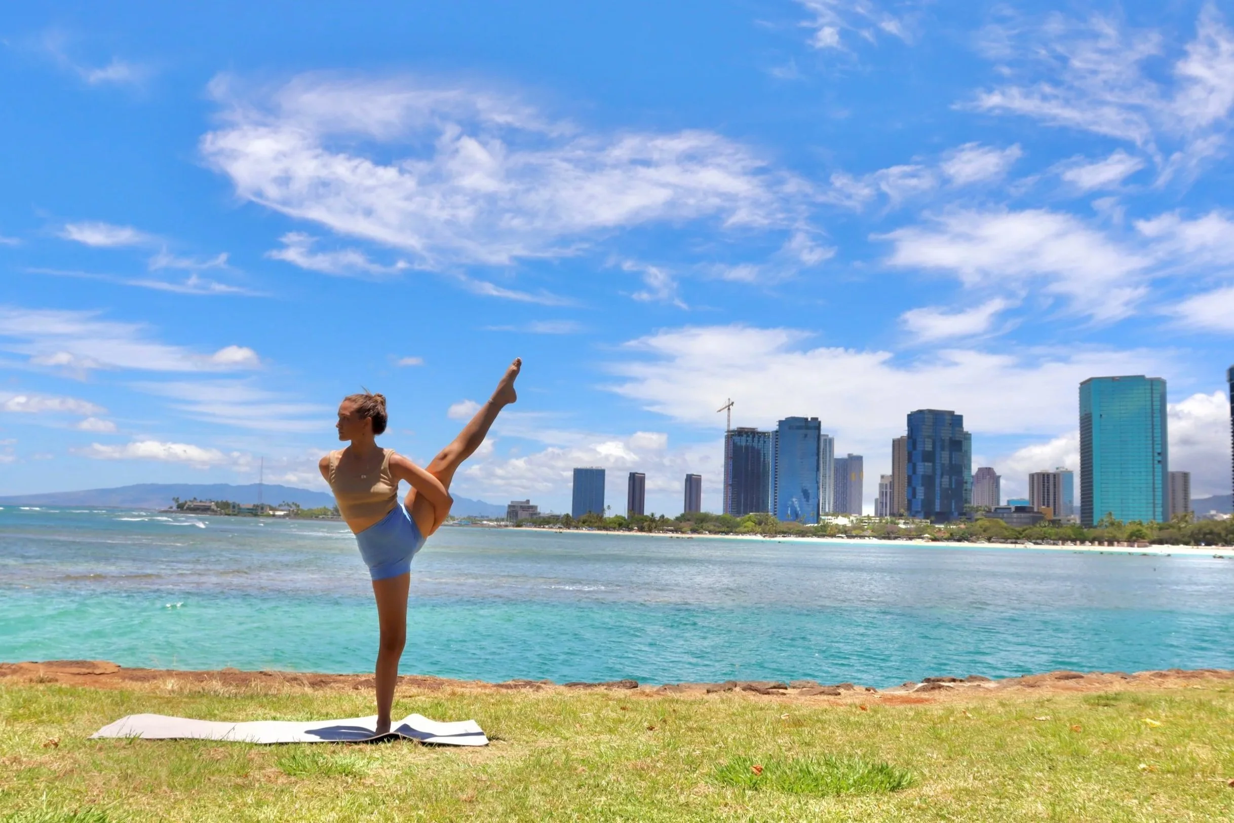 Sharonne of AO Yoga practicing Yoga for her Weekly Group Class in Magic Island Park in front of Ala Moana Beach Park, Kaka'ako, and Downtown Honolulu