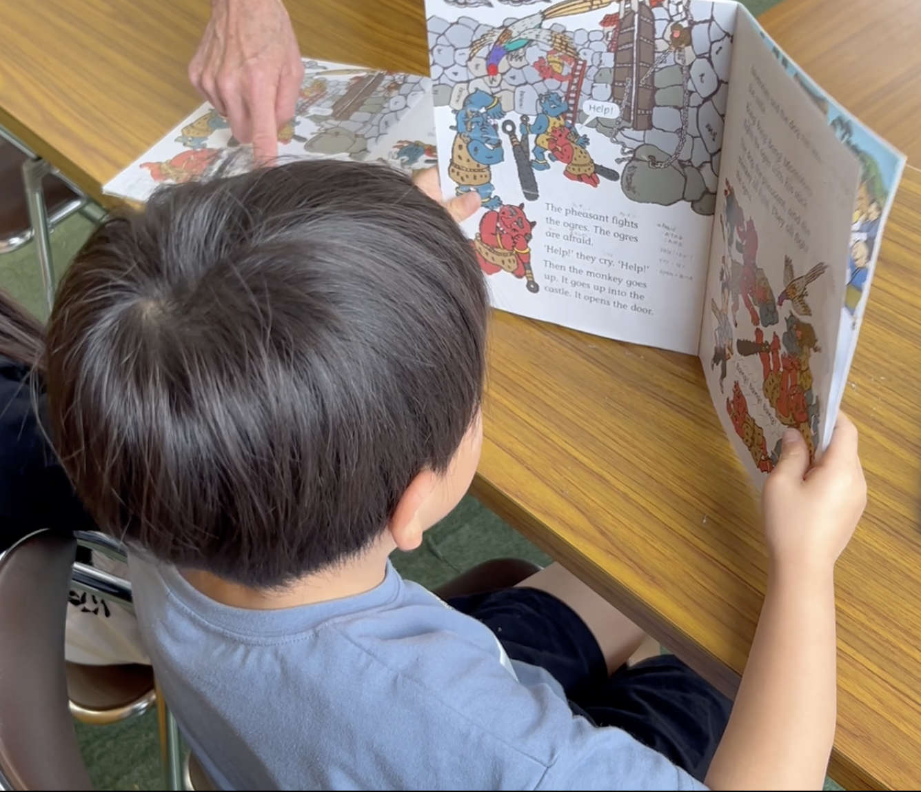 K.I.C.マウンテンクラスで英語の本を読みながら、語彙や表現を増やし、英語を読む楽しさを育てる様子。