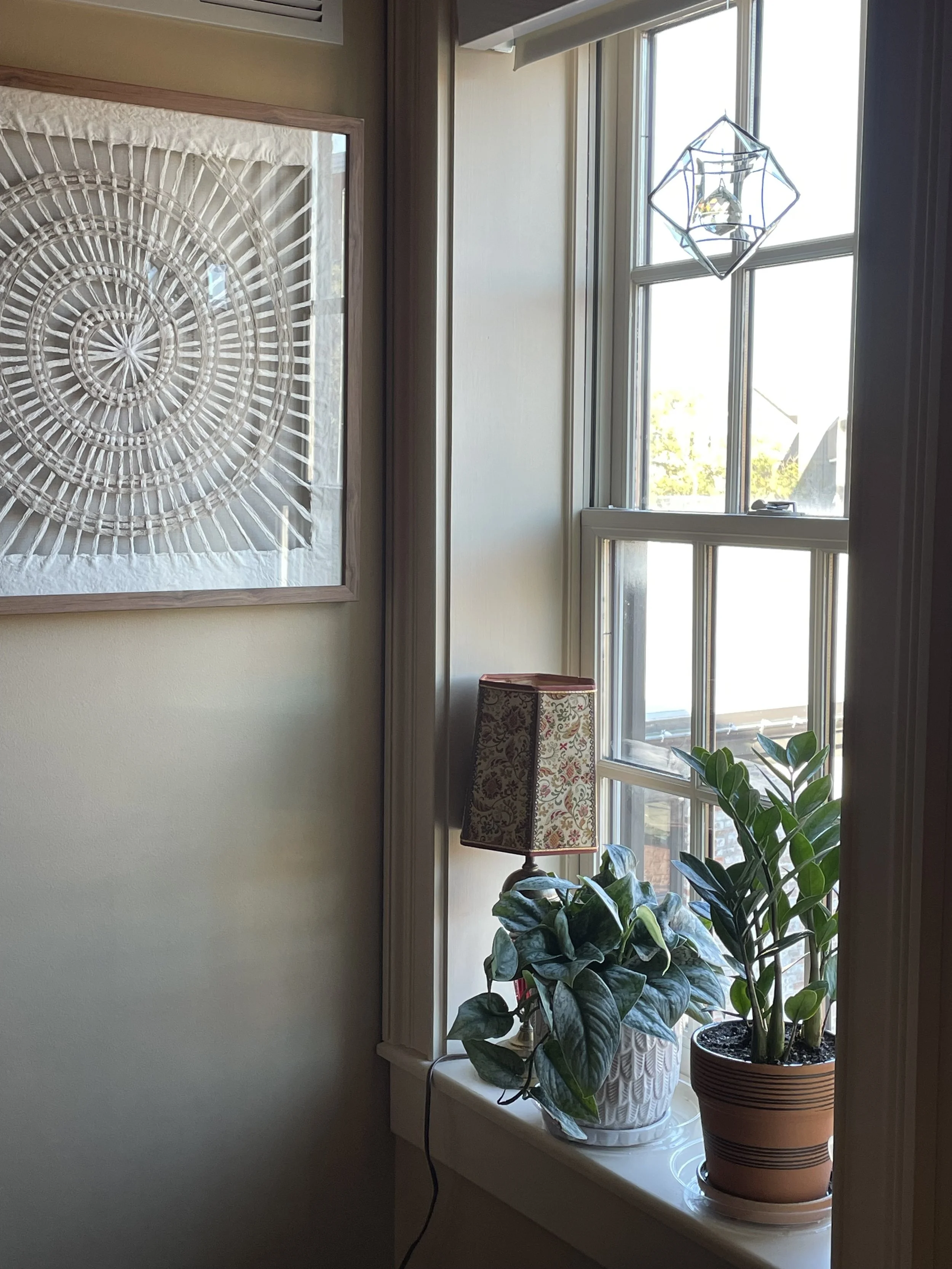 window with plants, hanging crystal & spiral art