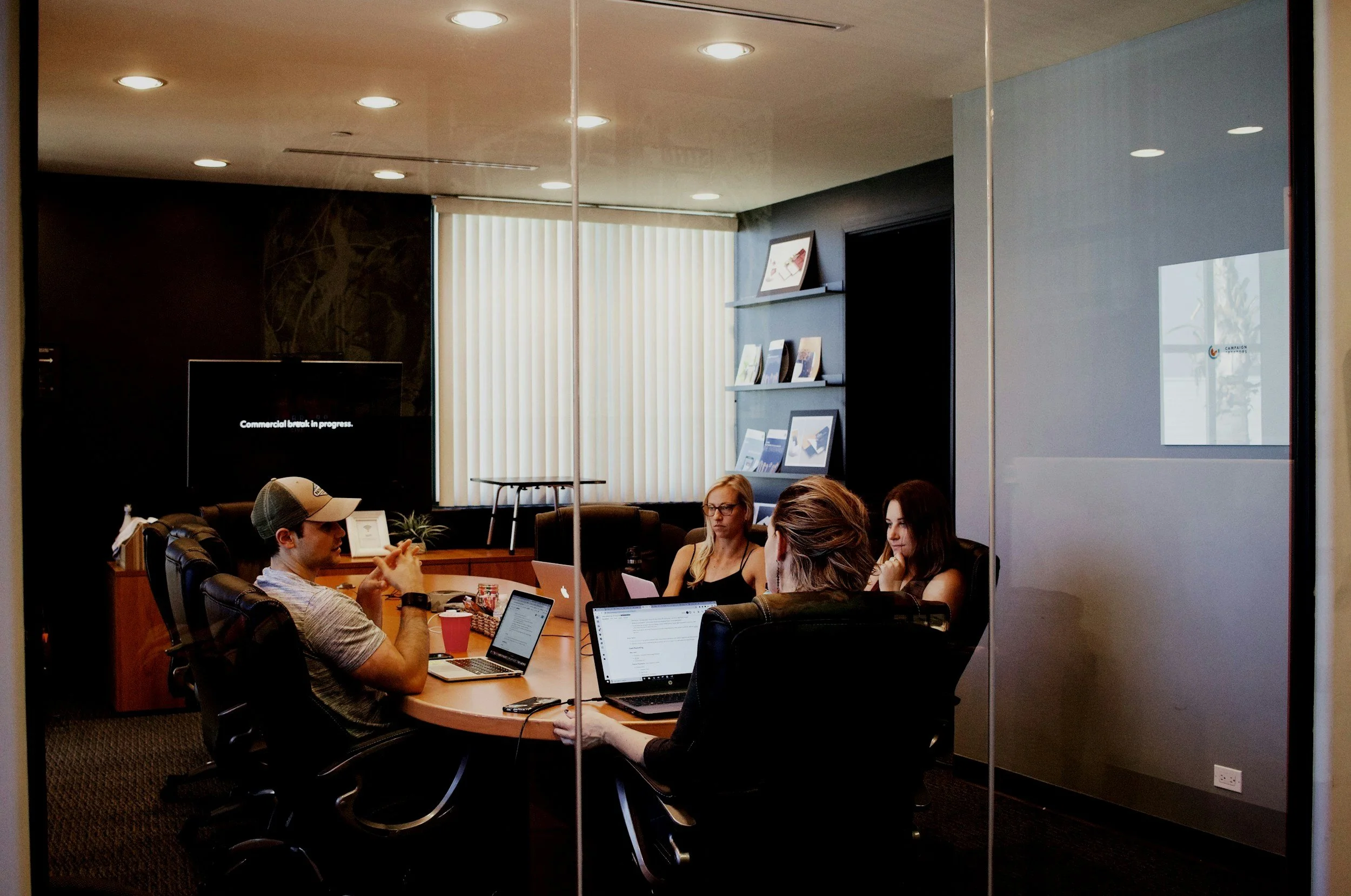 People having a meeting in a conference room with laptops.