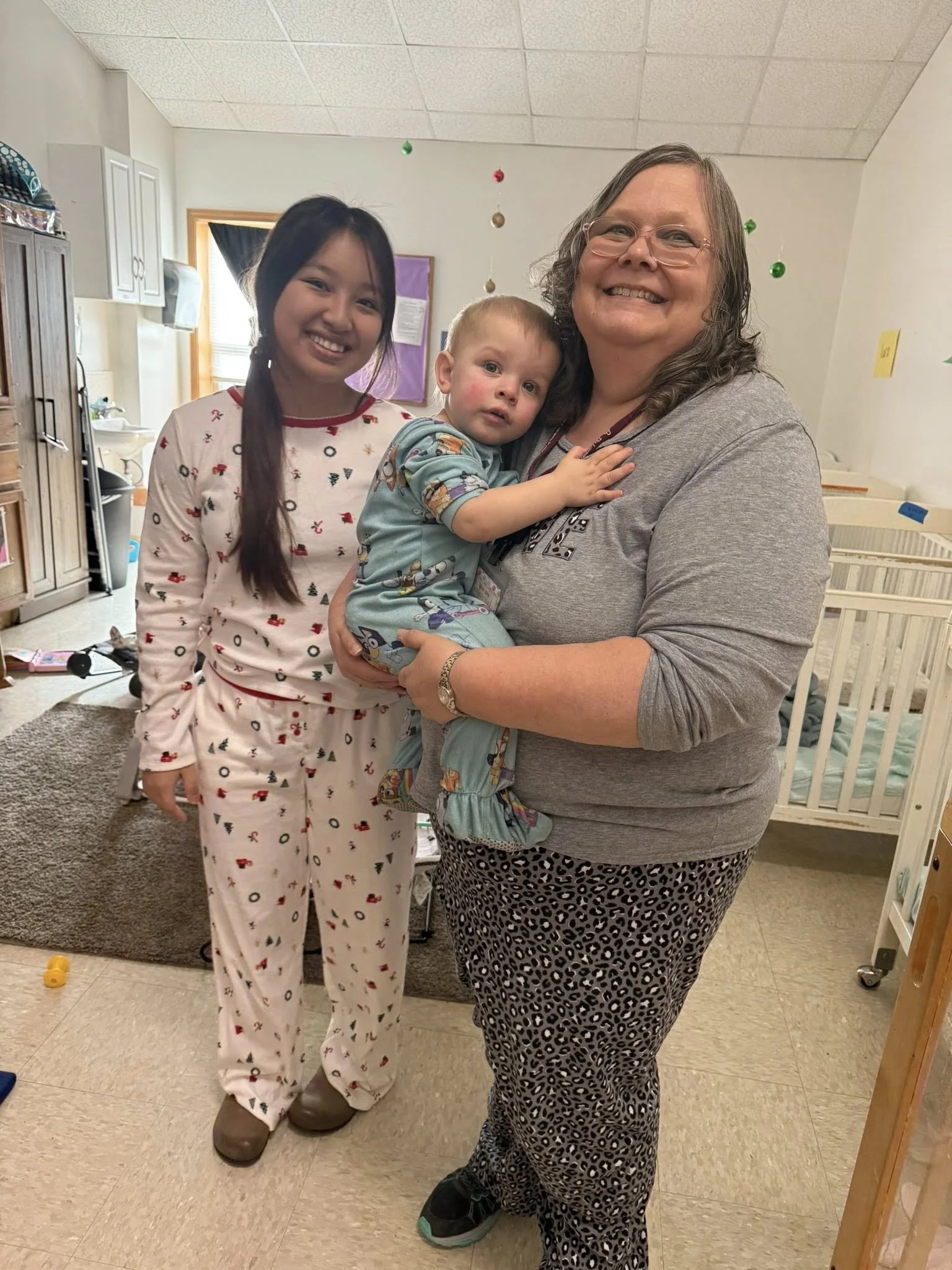 GF 2026 Jan teachers in nursery holding child.jpg