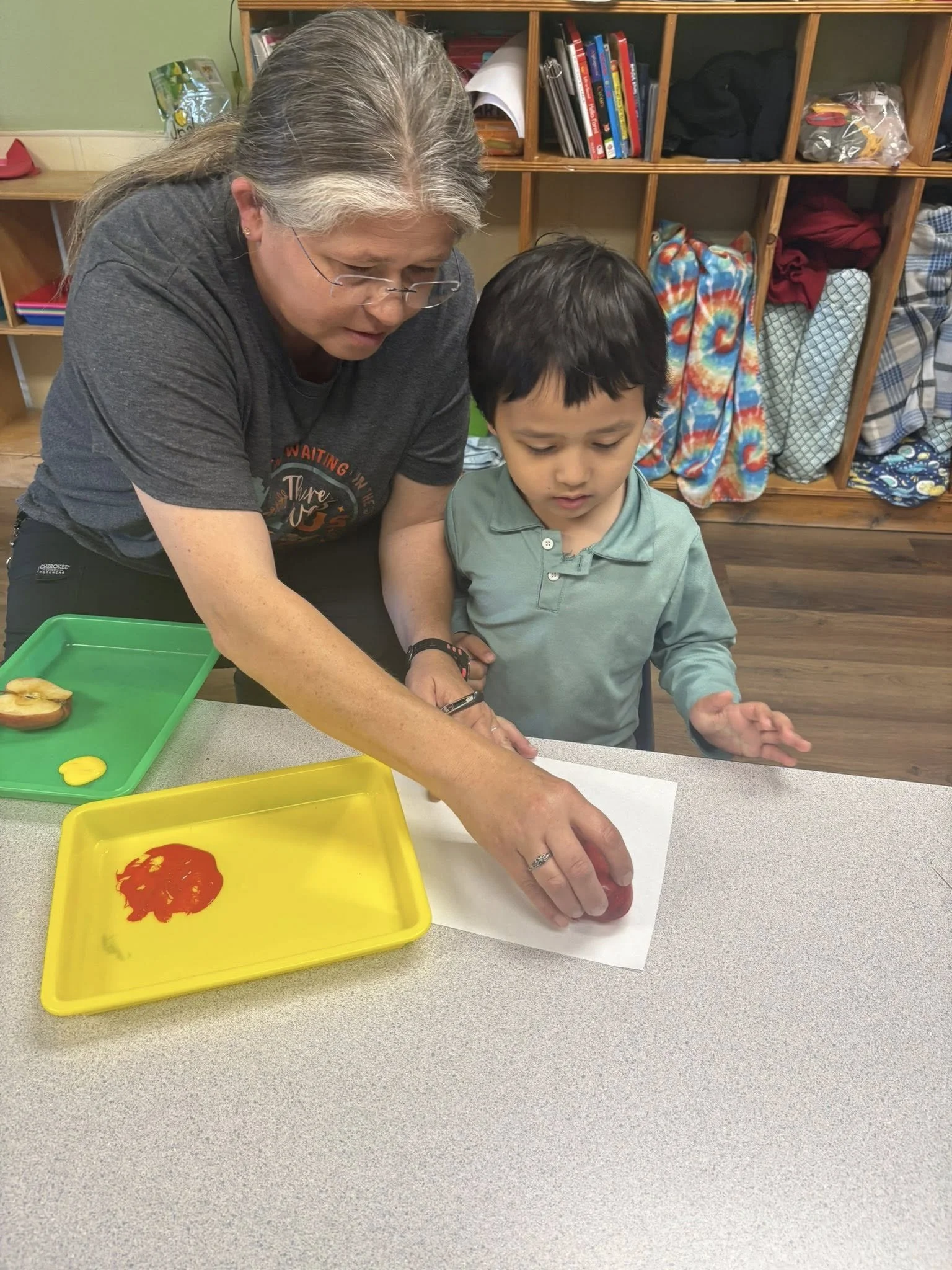 GF teacher and child apple painting.jpg