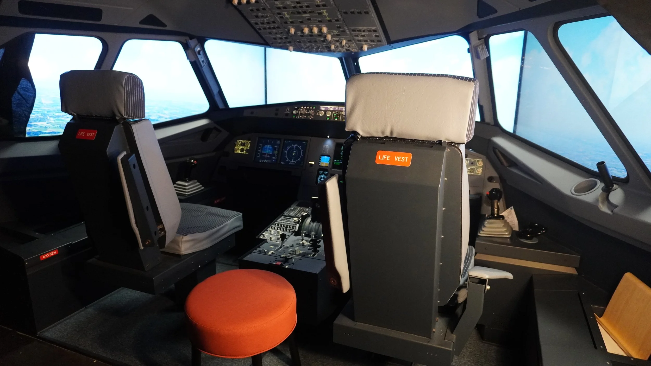 Cockpit complet Airbus A320 sur simulateur de vol professionnel avec sièges pilotes commandes de vol écrans avioniques et environnement aviation civile formation pilote de ligne