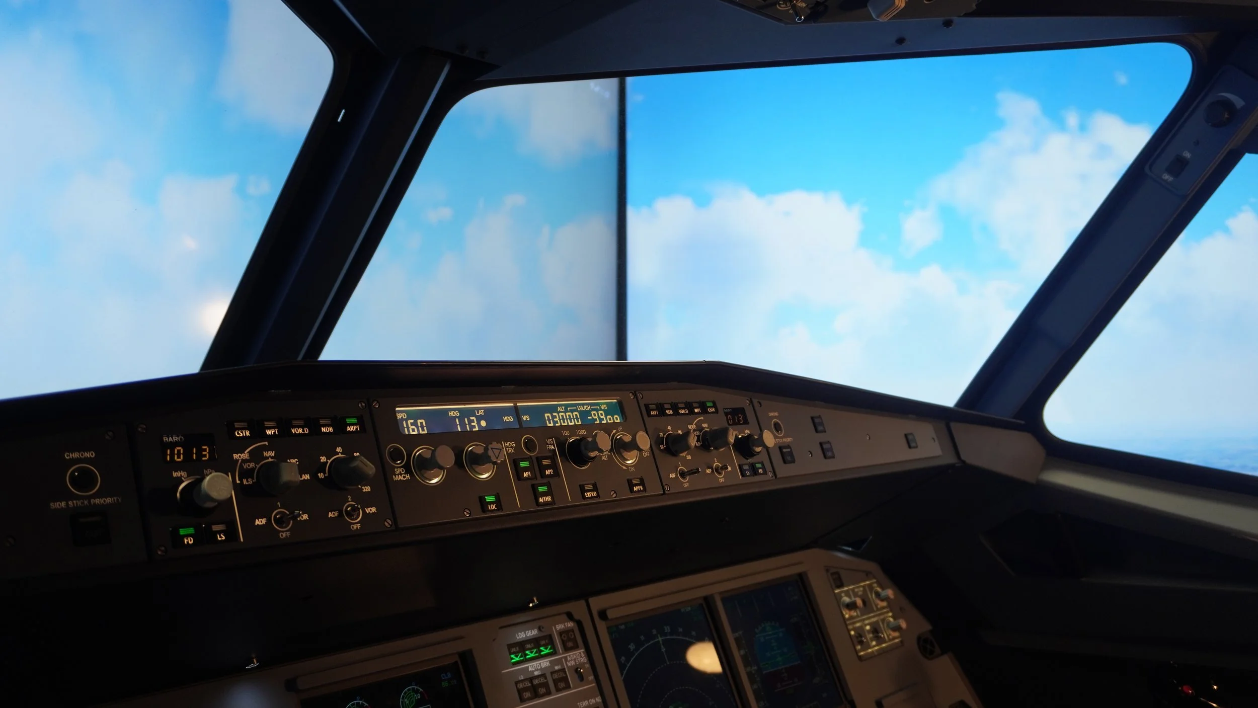 Vue pare-brise nuages ciel bleu cockpit Airbus A320 sur simulateur de vol professionnel avec pilote automatique panneaux FCU et environnement aérien aviation civile