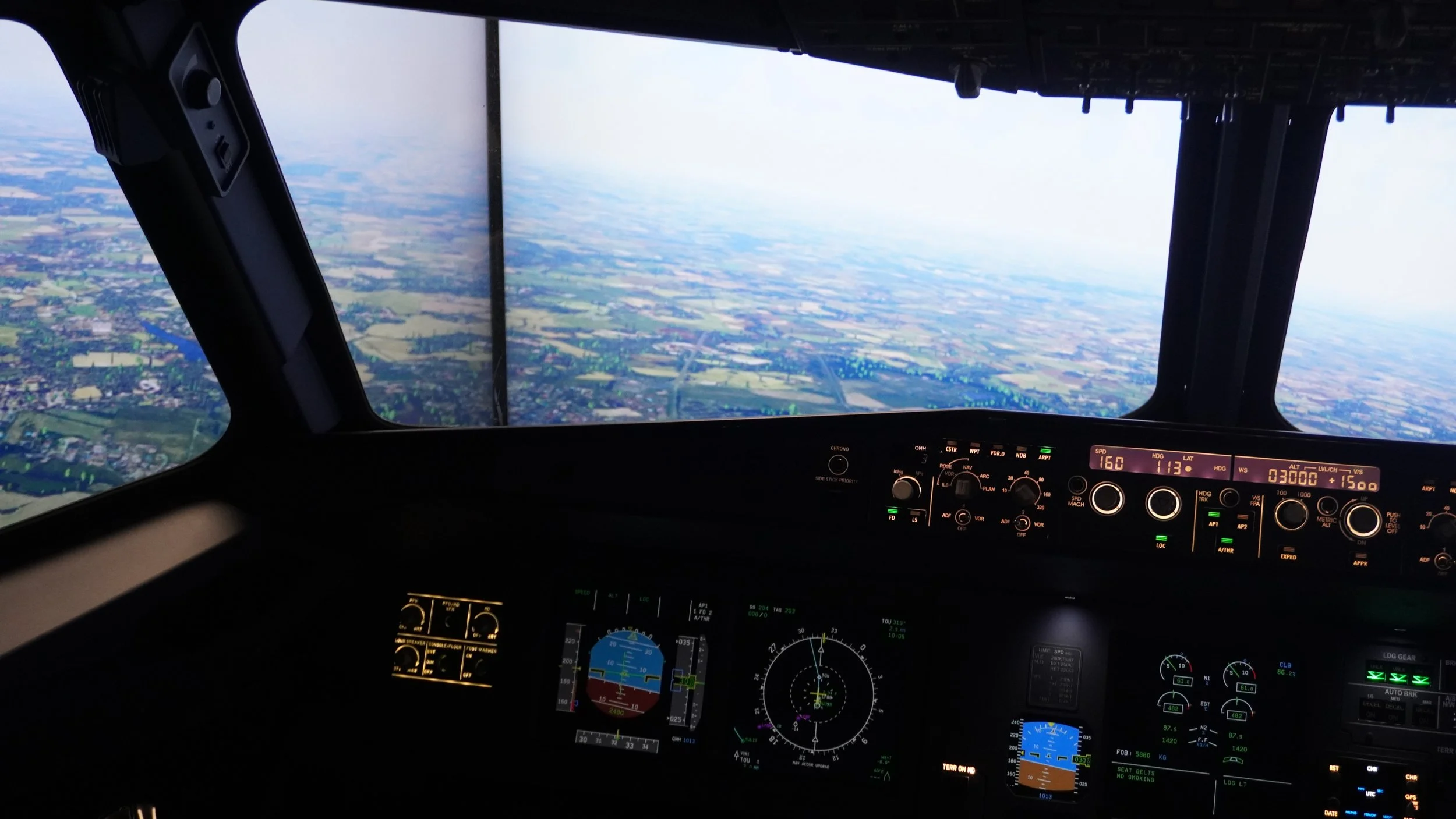 Vue pilote Airbus A320 en simulateur de vol professionnel avec écrans de navigation cockpit immersif et paysage aérien aviation civile réaliste