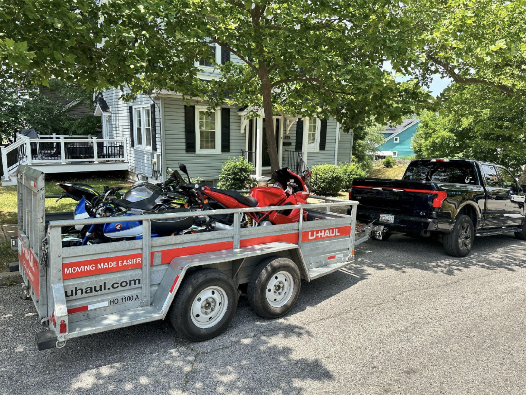 Ford F-150 Lightning showcasing towing capacity by hauling three motorcycles