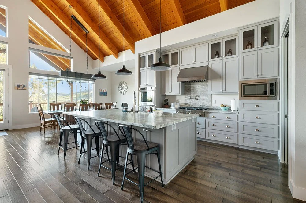 A kitchen remodel in a Redding CA home with exposed wood A-frame ceiling, and white and gray cabinets