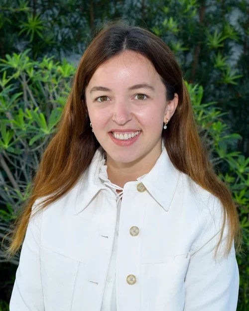 Catalina Arzani_Woman Smiling, white jacket, green background -Profile Professional Picture
