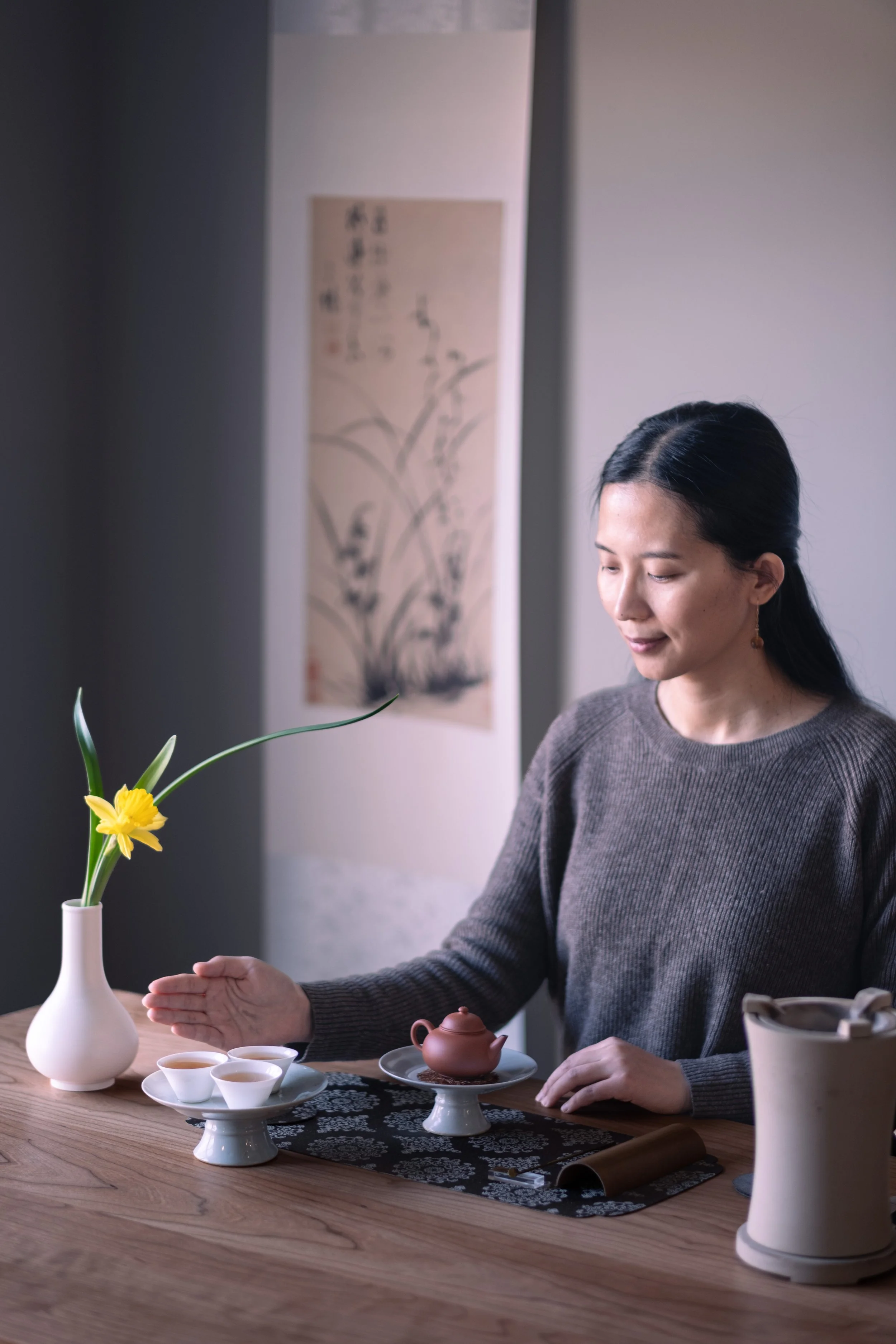 Mengyan Gong sits at a tea table with a teapot and teacups at Teasthetic's NYC Tea Studio.