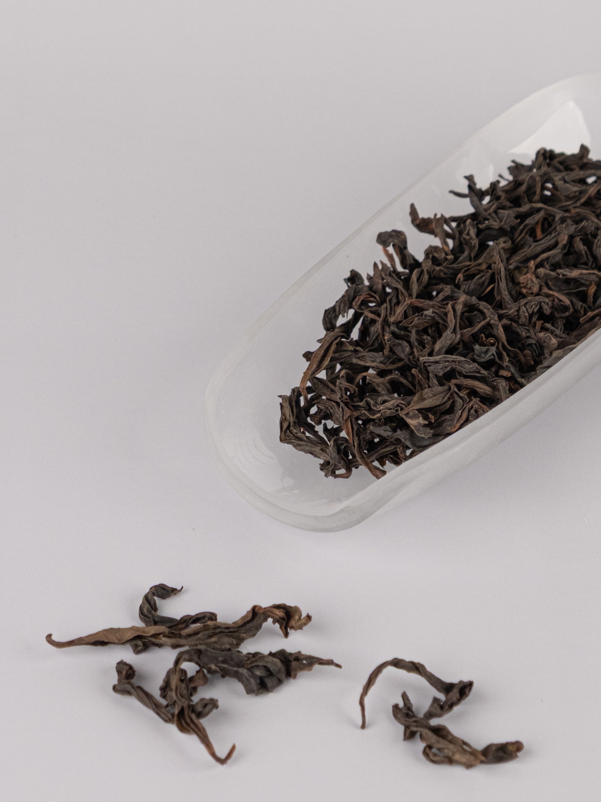 Dry Chinese tea leaves in a white tea holder.