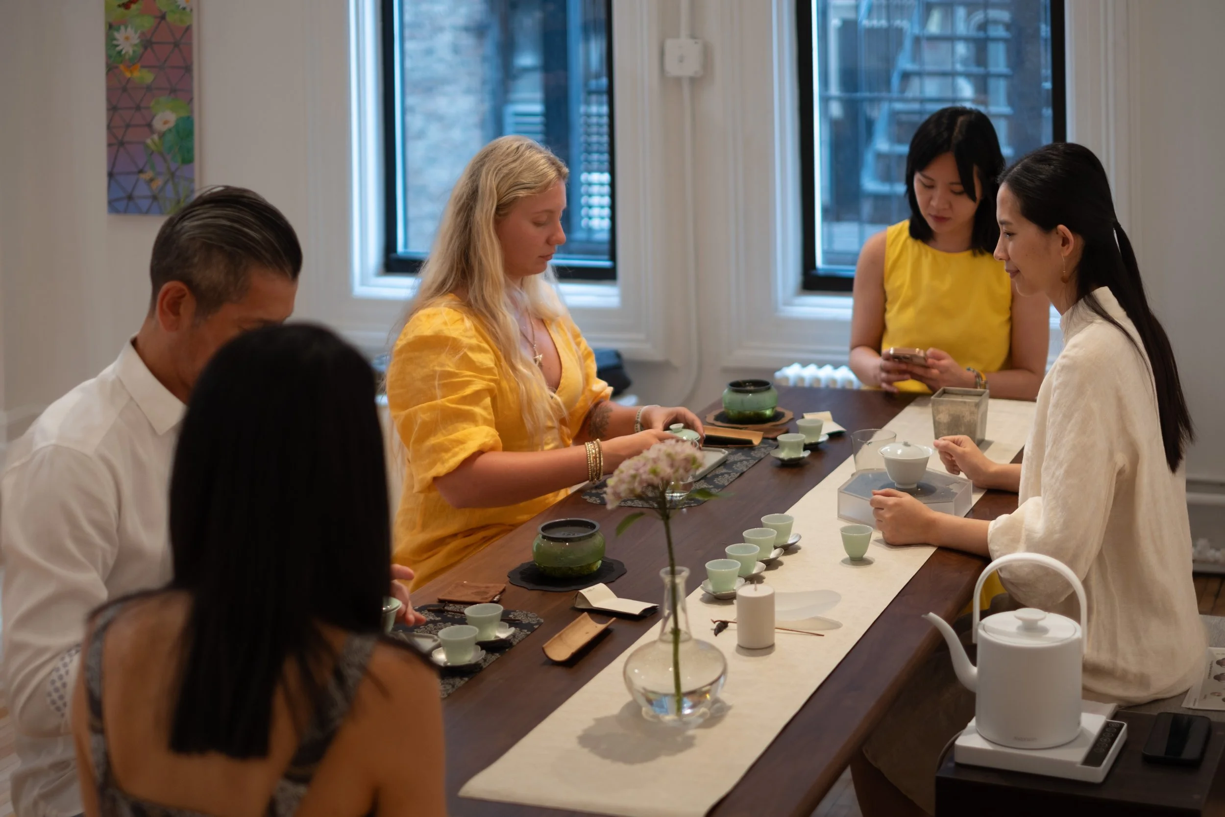 Mengyan Gong guides guests through a Chinese tea ceremony workshop at Teasthetic in NYC, with teaware arranged on a tea stage.