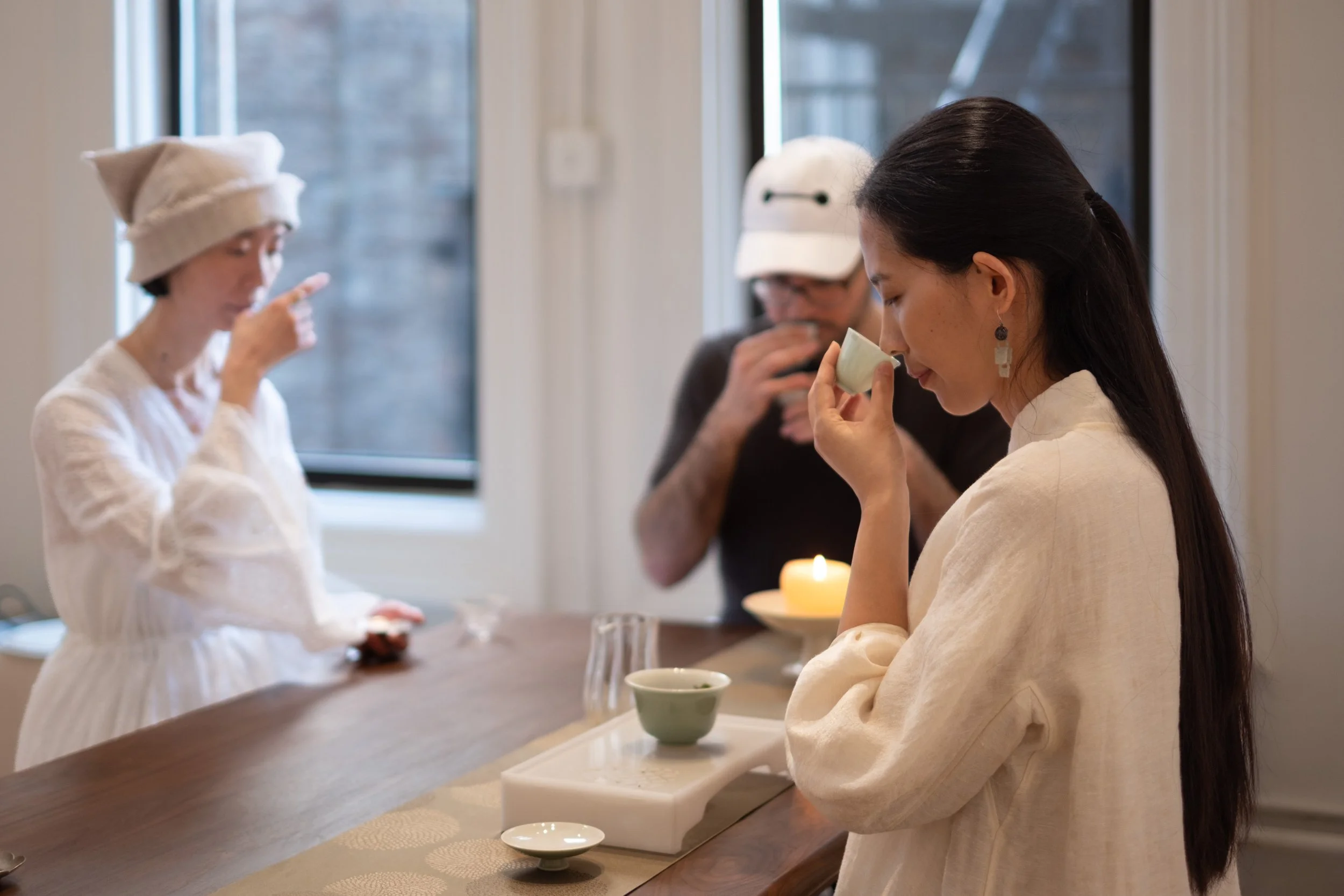 Mengyan Gong smells the aroma of Chinese tea while two guests taste tea at Teasthetic's NYC Tea Studio.