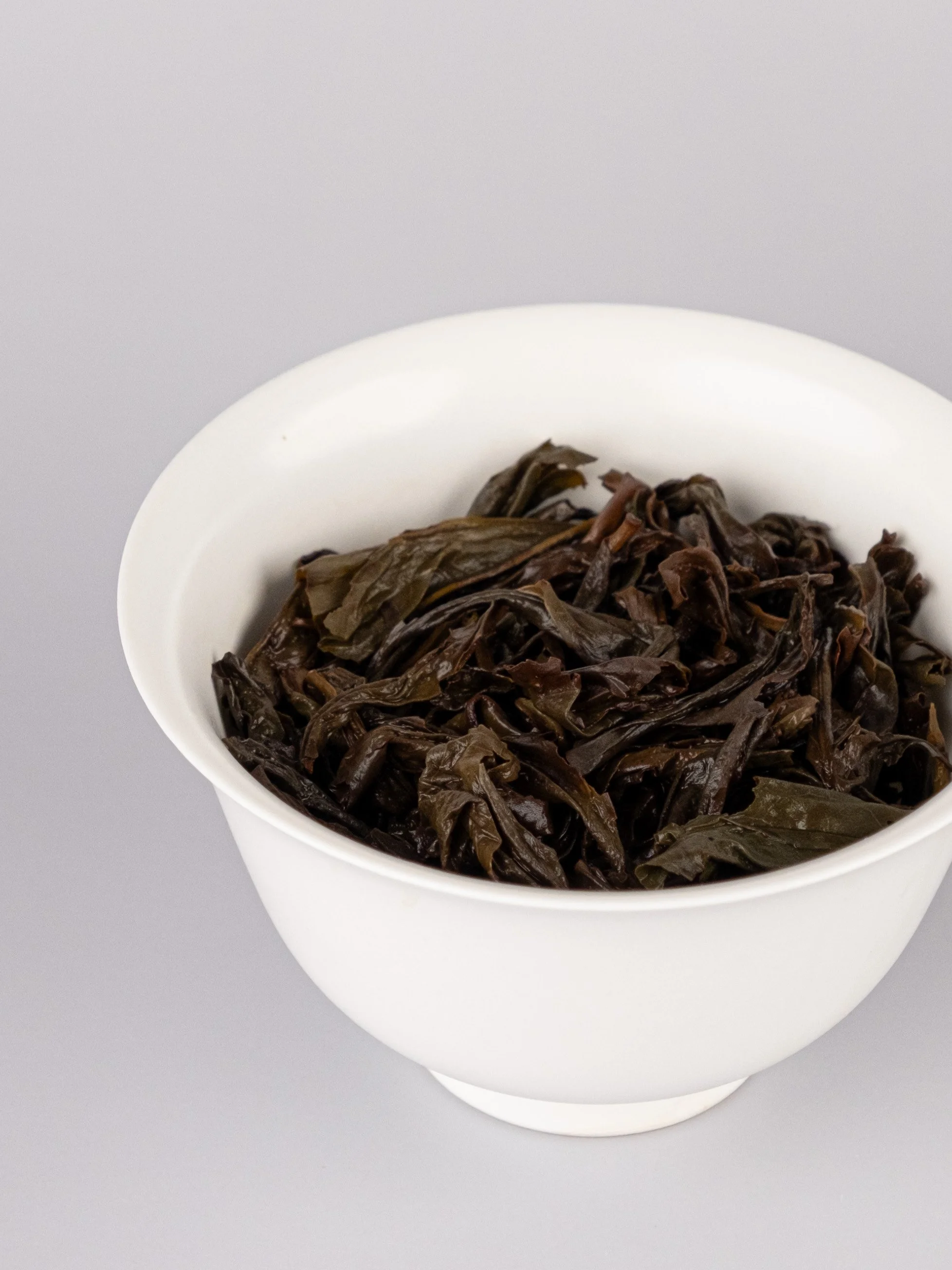Brewed Chinese tea leaves in a white gaiwan.