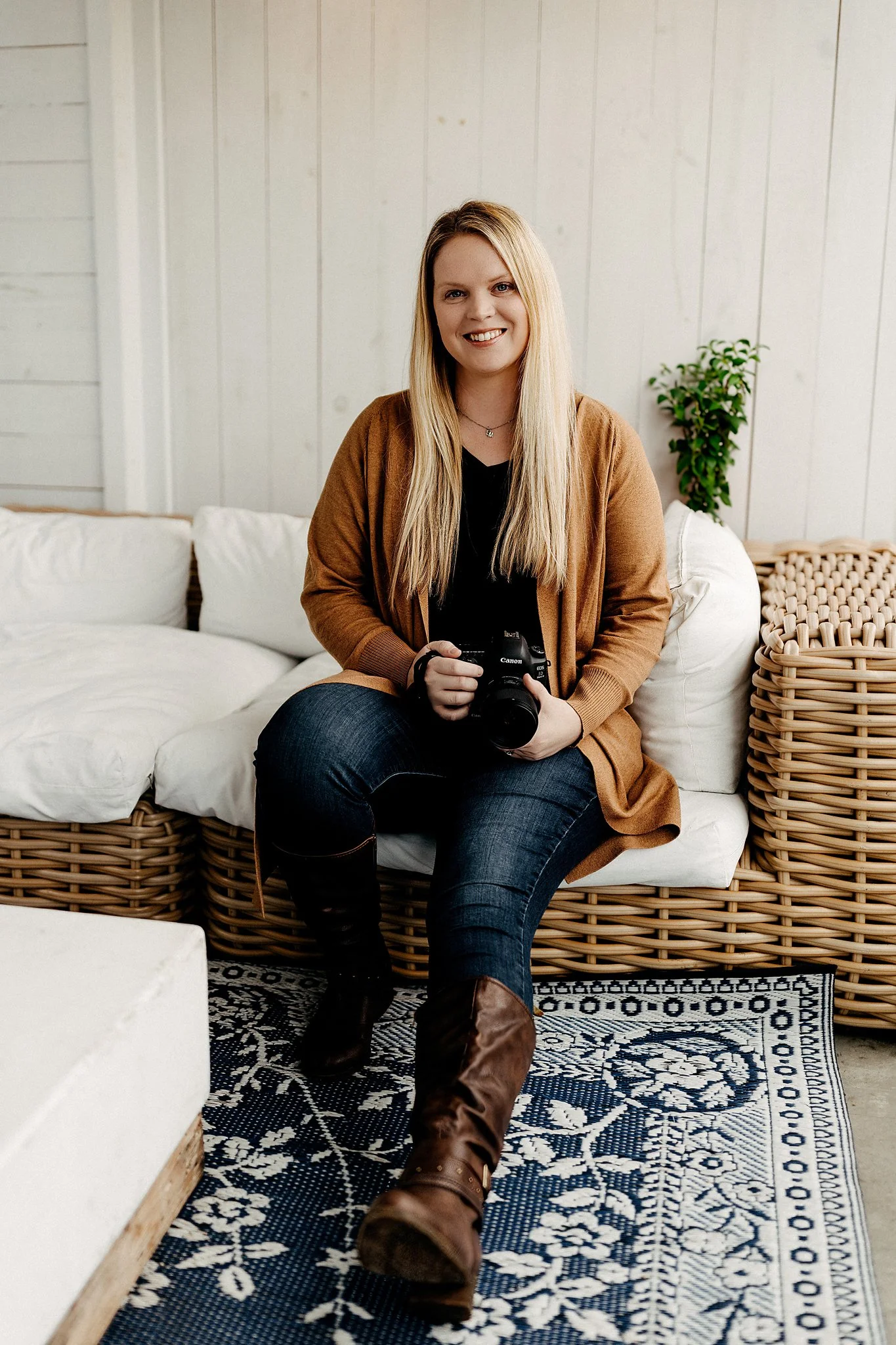 Pace FL Family Photographer Sarah Rice of June Sunrise Photography poses for a headshot while she holds her professional camera.