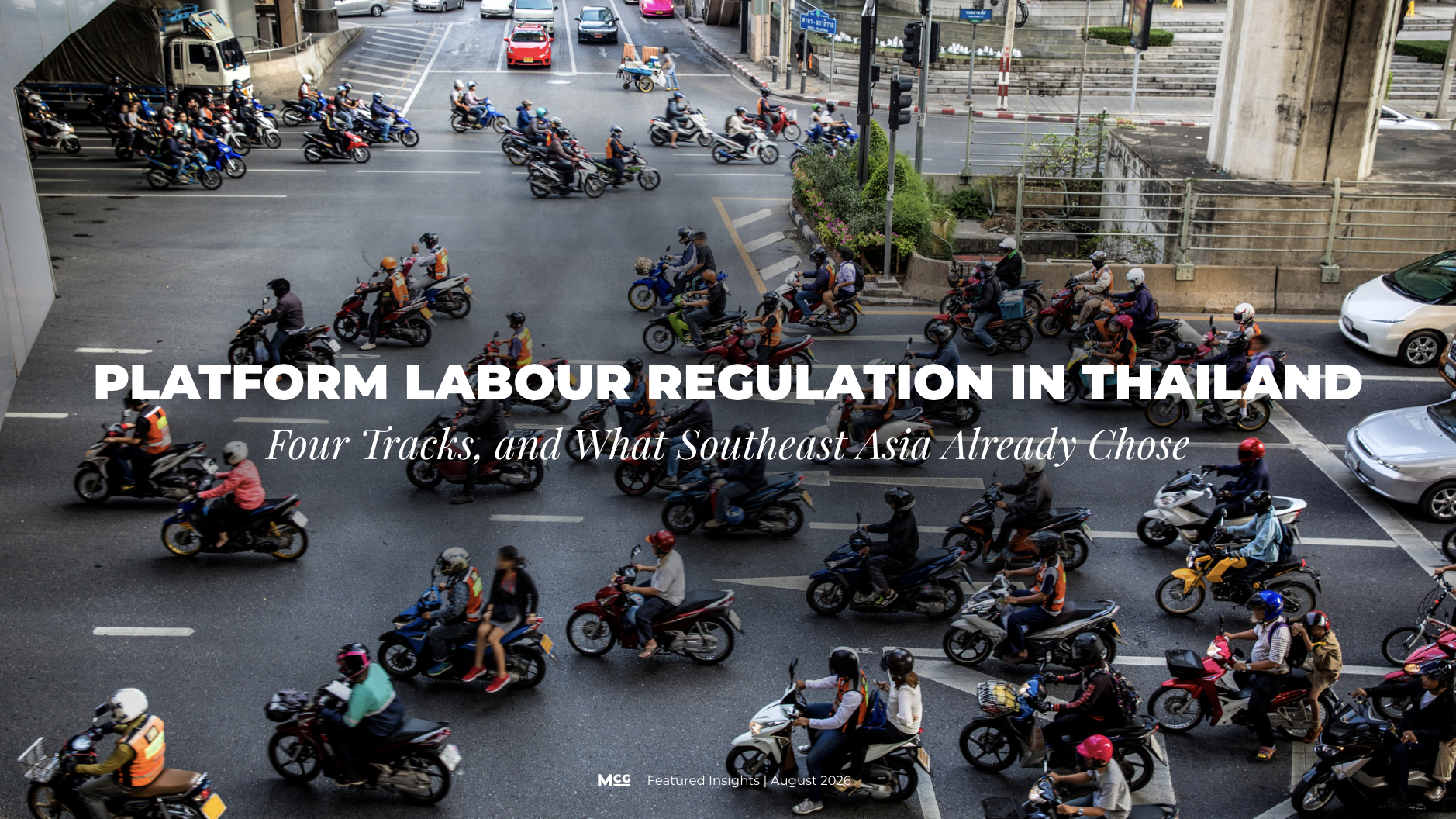 Motorcycle delivery riders waiting at a Bangkok intersection