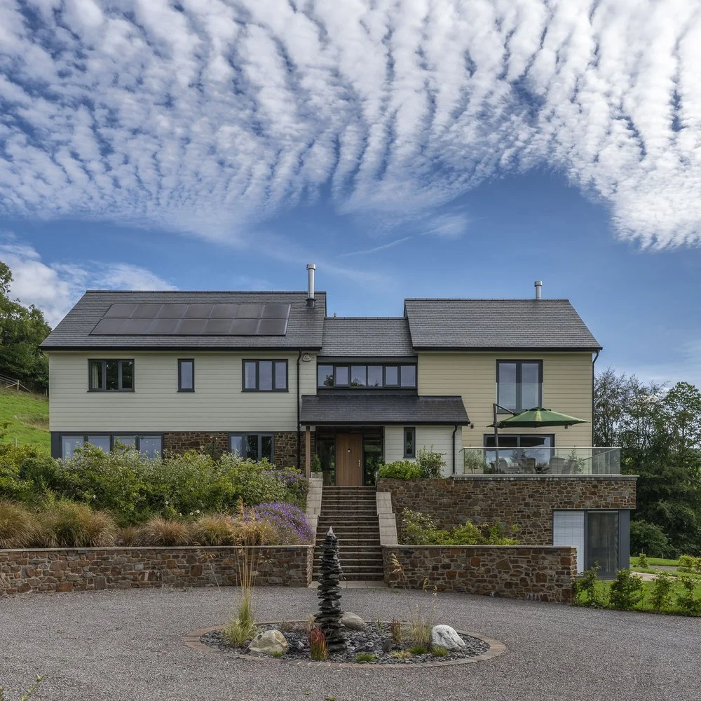 Exterior property photography of large house with cream cladding on a sunny day