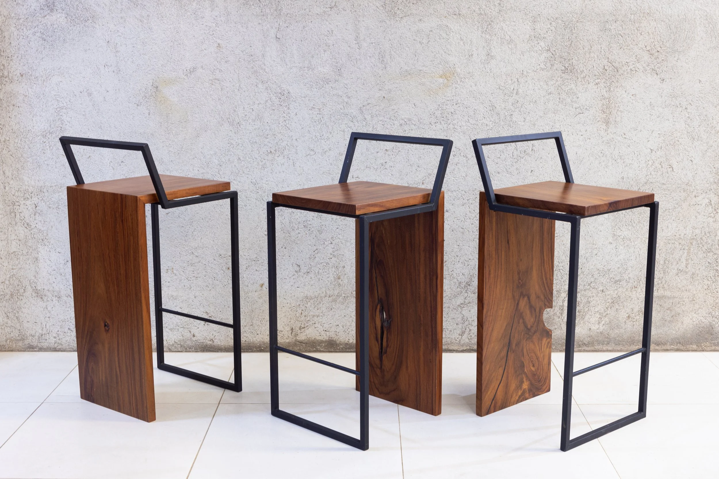 Waterfall stool handcrafted from solid Guanacaste wood with minimalist steel frame