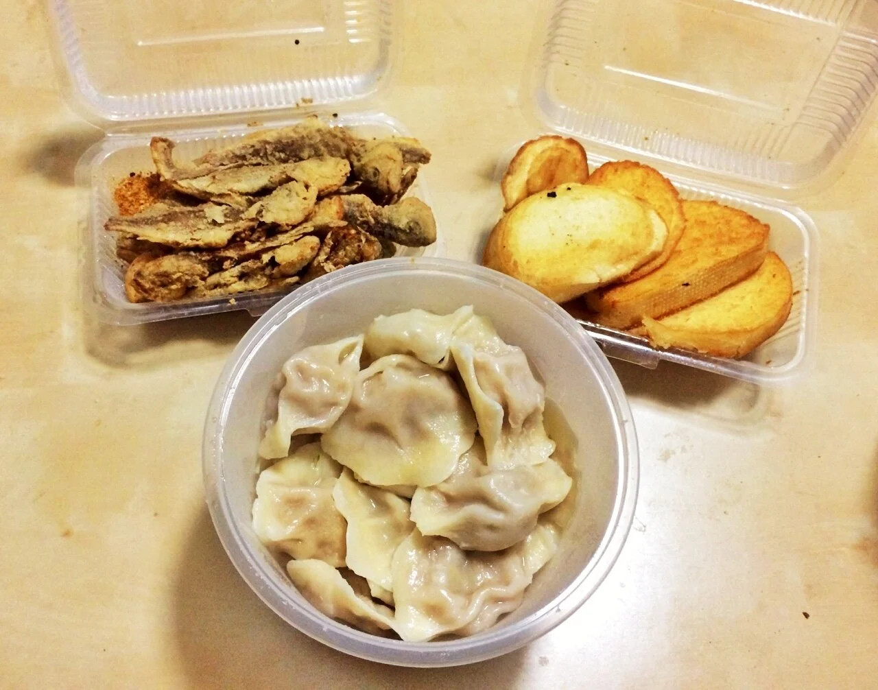 Chinese takeout: dumplings, whole fried fish, and garlic bread