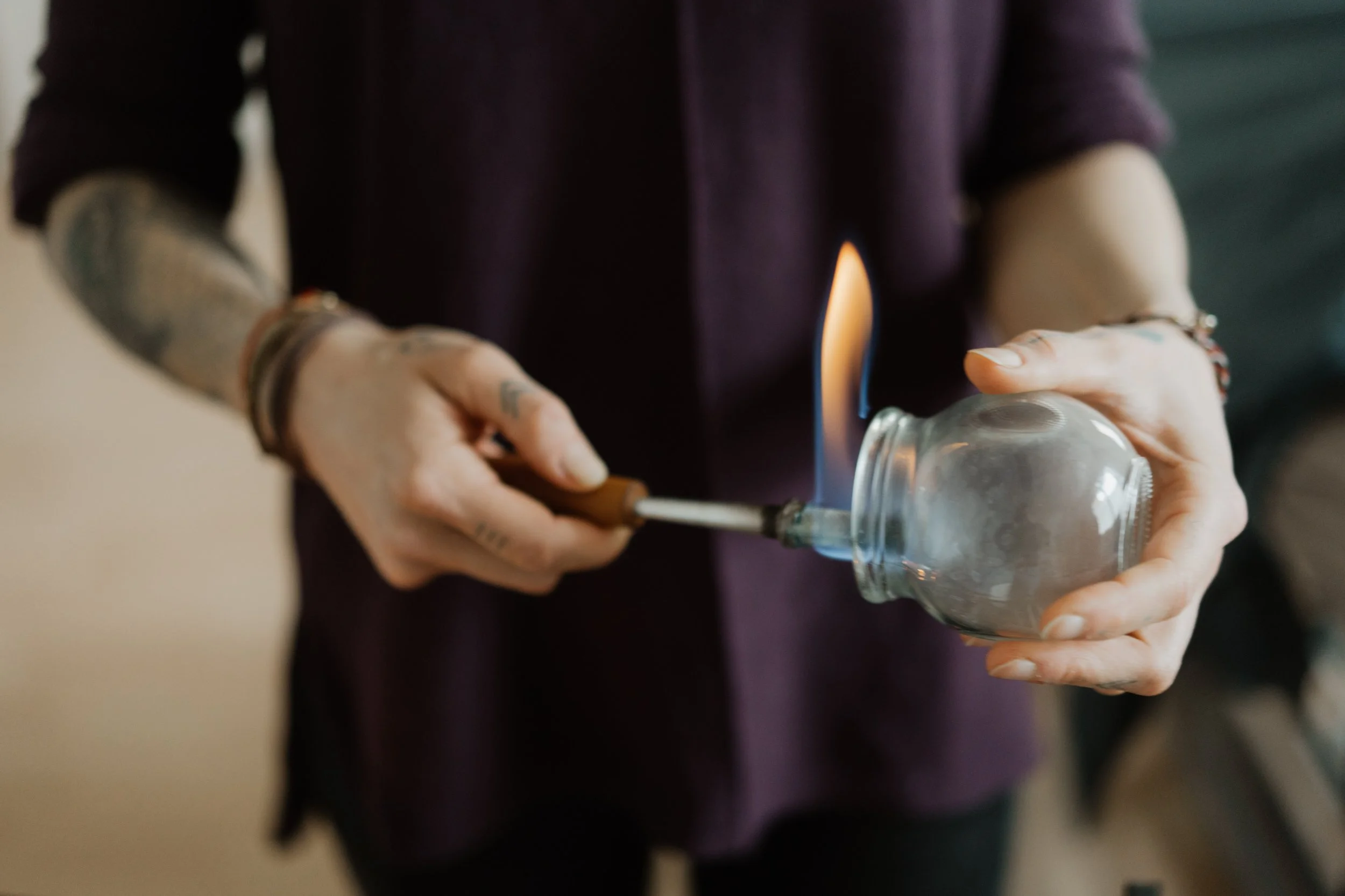 Person hält ein Schröpfglas