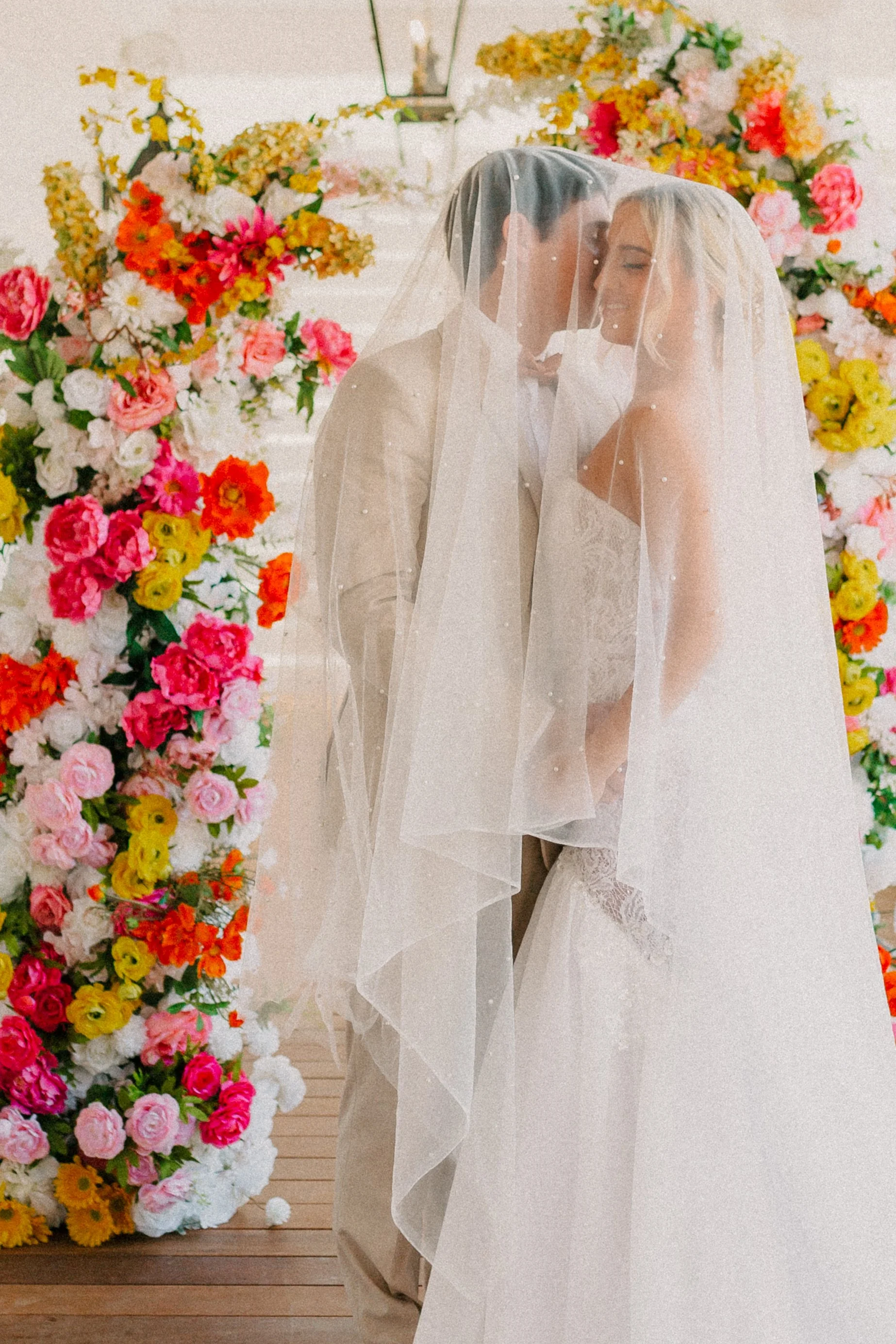 Bride standing in front of colorful floral installation during Charleston wedding