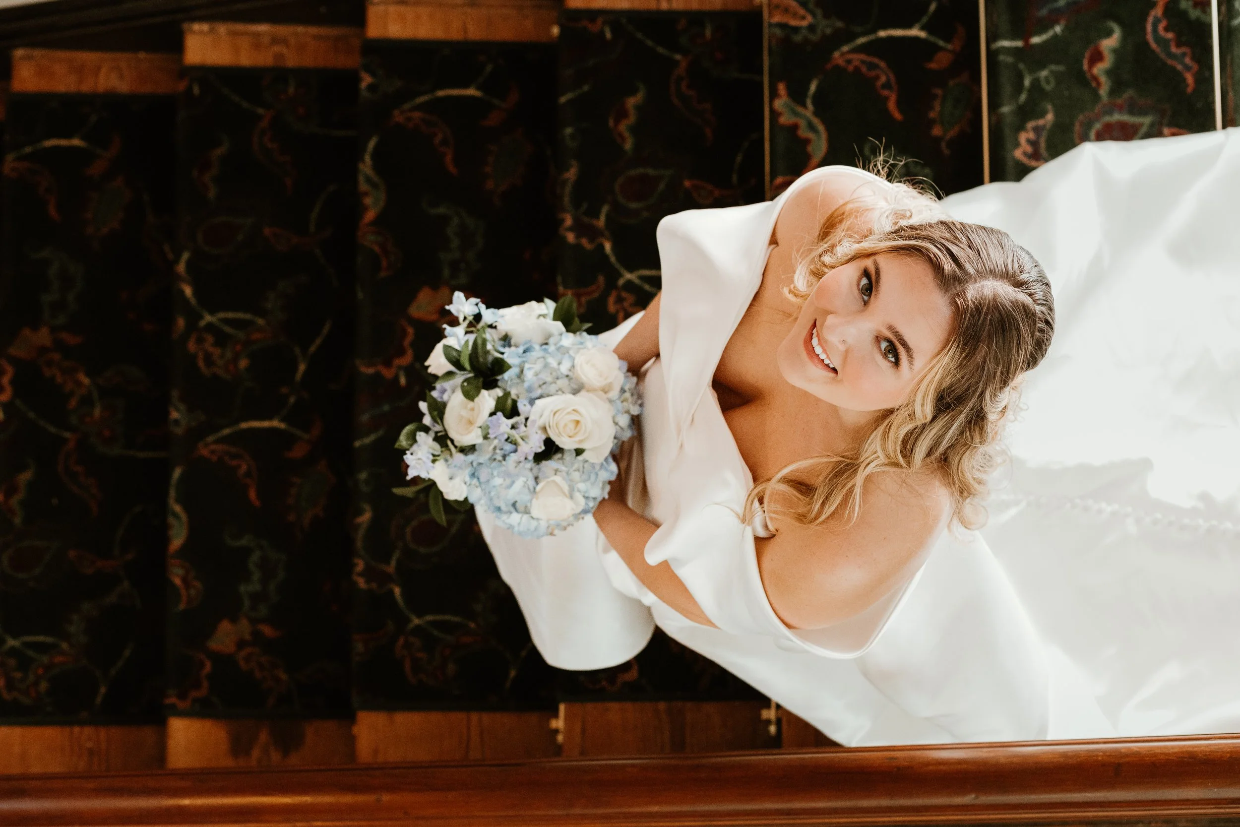 Bride holding a bouquet during a Charleston wedding, captured from above in an elegant bridal portrait