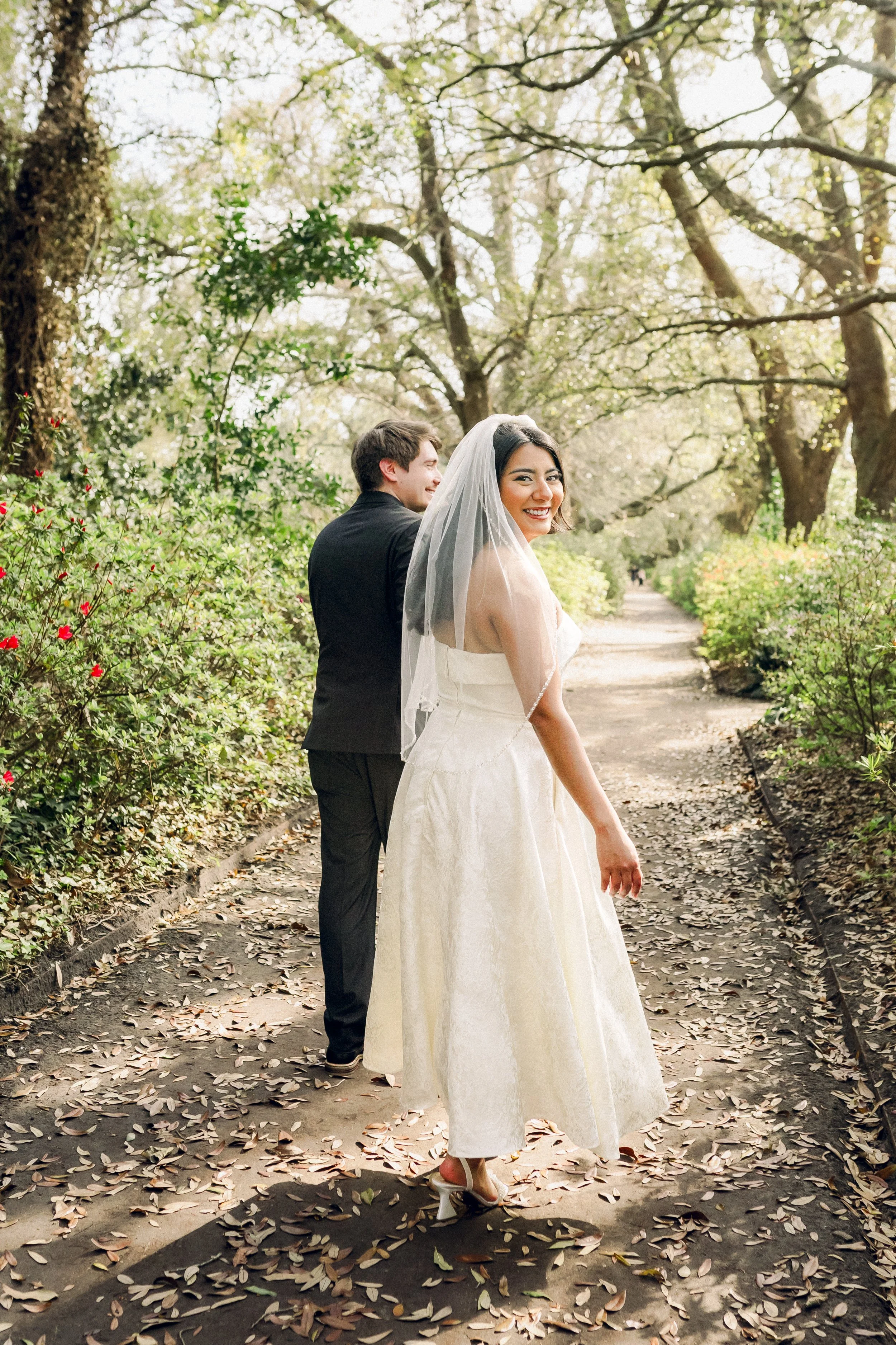 Bride walking through lush garden setting during Charleston wedding day