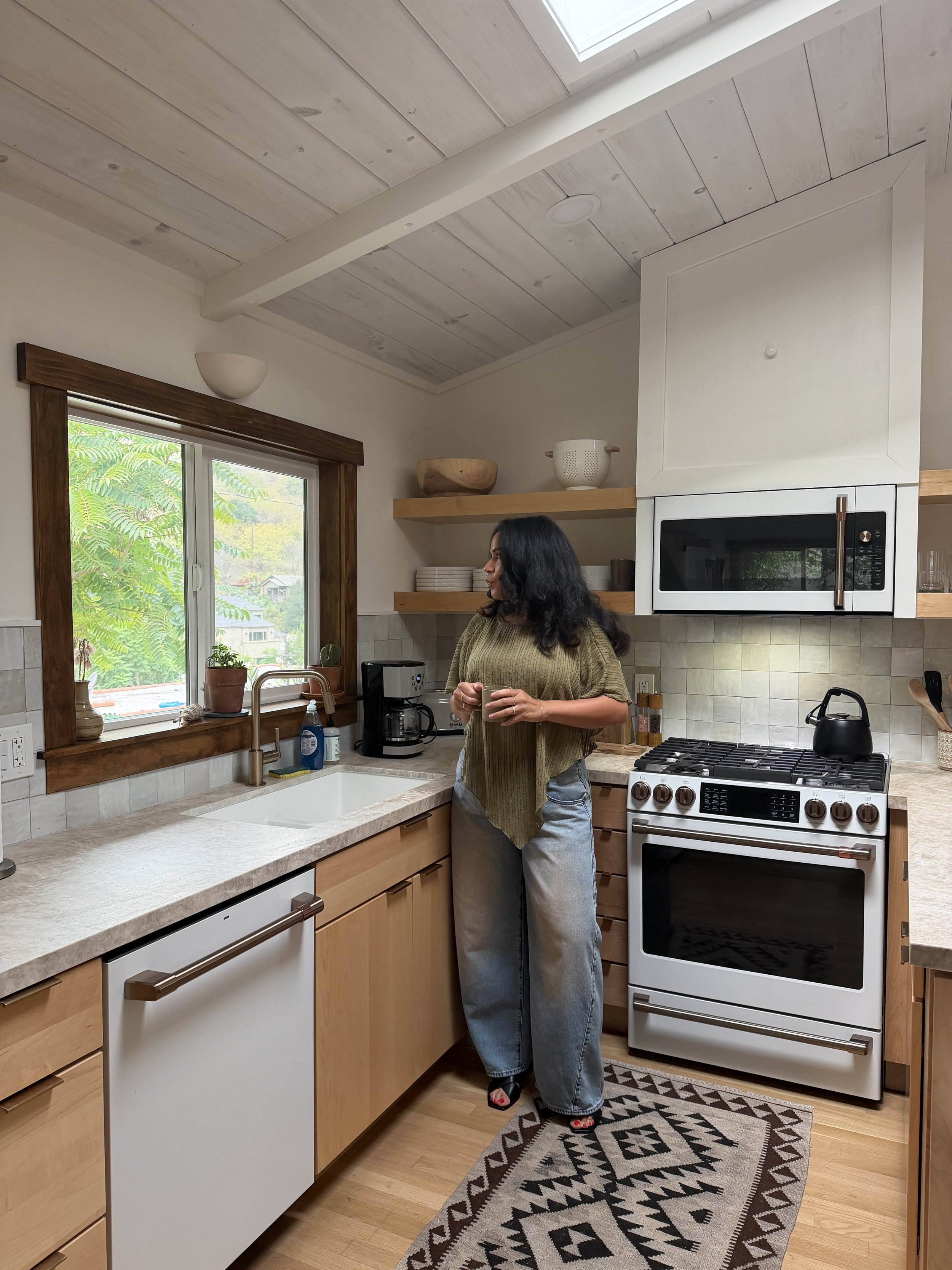 Victoria Chantel standing in a bright kitchen holding a mug