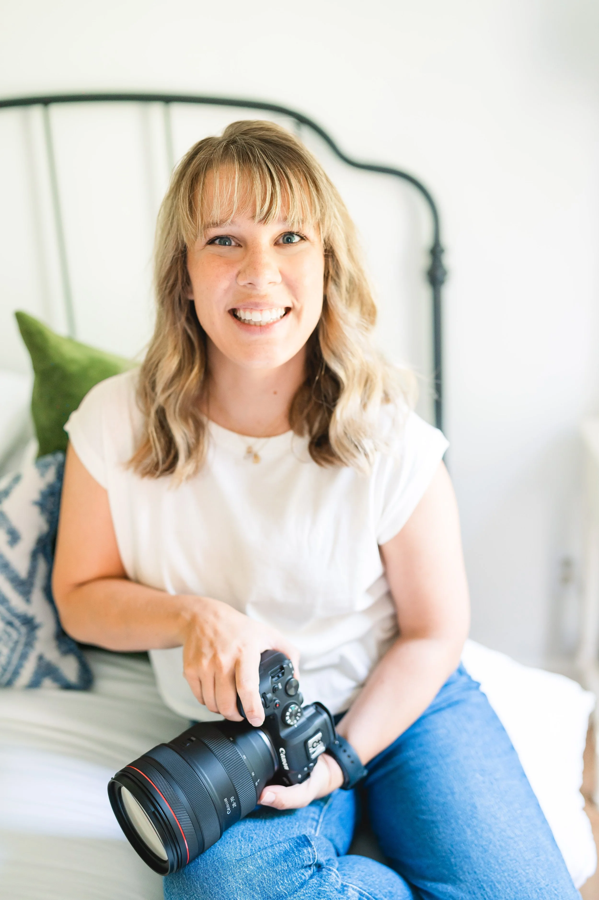 photographer in Raleigh NC Callie Doty smiling and holding camera