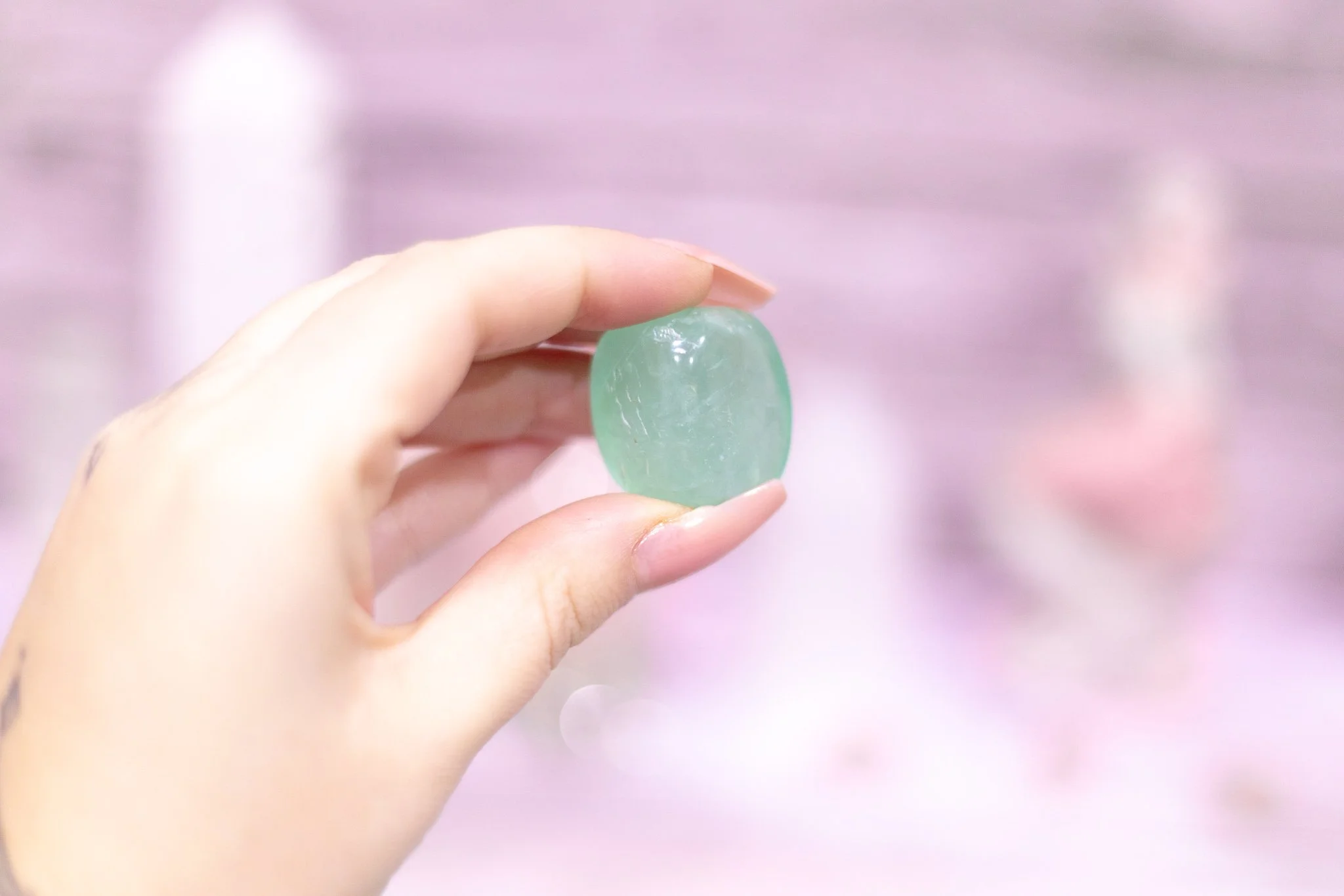 green fluorite tumble stones crystals woman holding