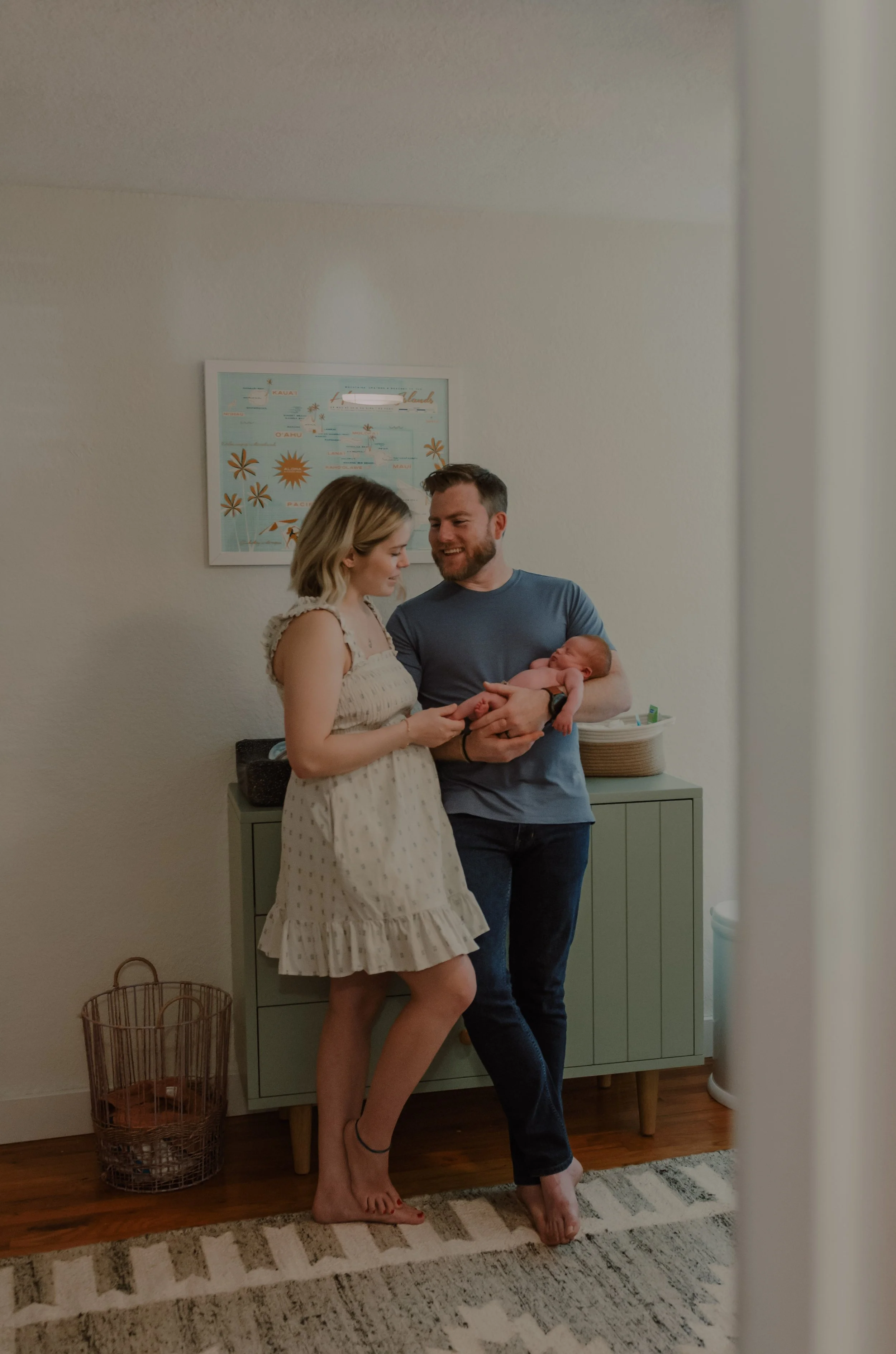 Indoor newborn family photo session in Salem Oregon of parents holding baby in nursery