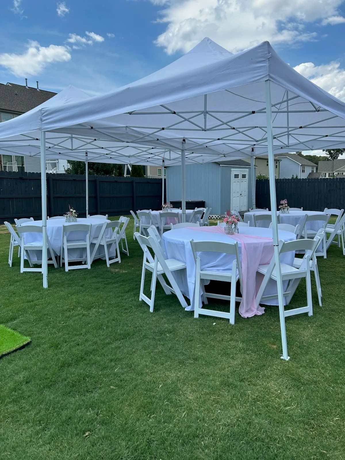 two 10x20' pop up tents combined to form 20x20' tent with tables and chairs underneath