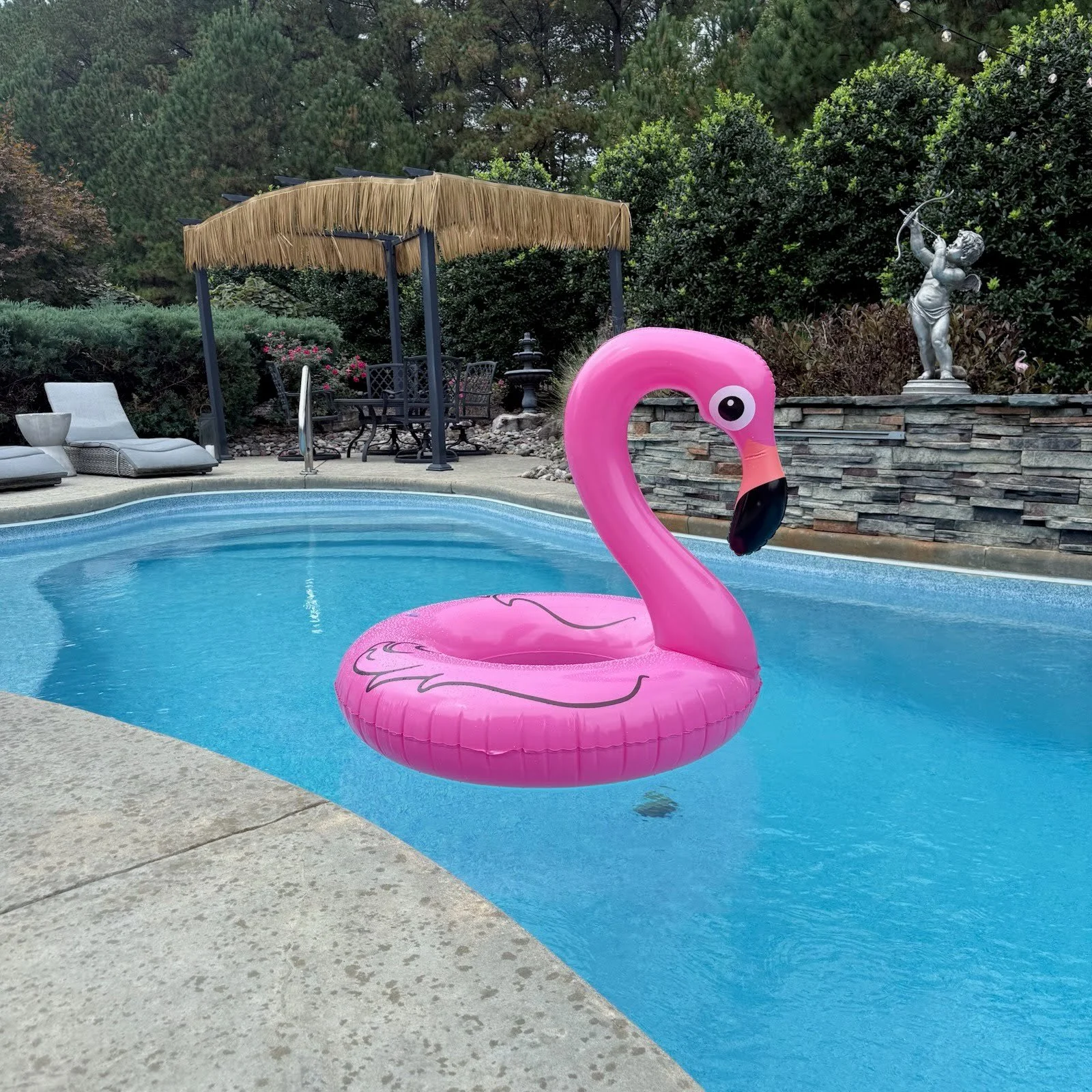 pool party showing flamingo floaty with tiki panel in background
