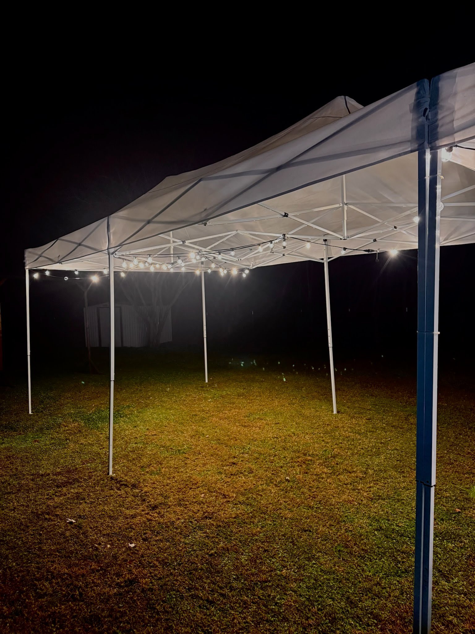 10x20' pop up tent lit at night by string lights