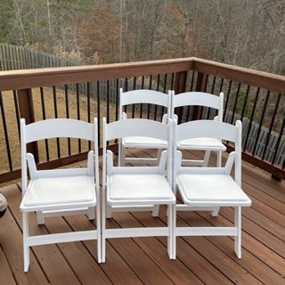 white resin padded folding chairs in a group