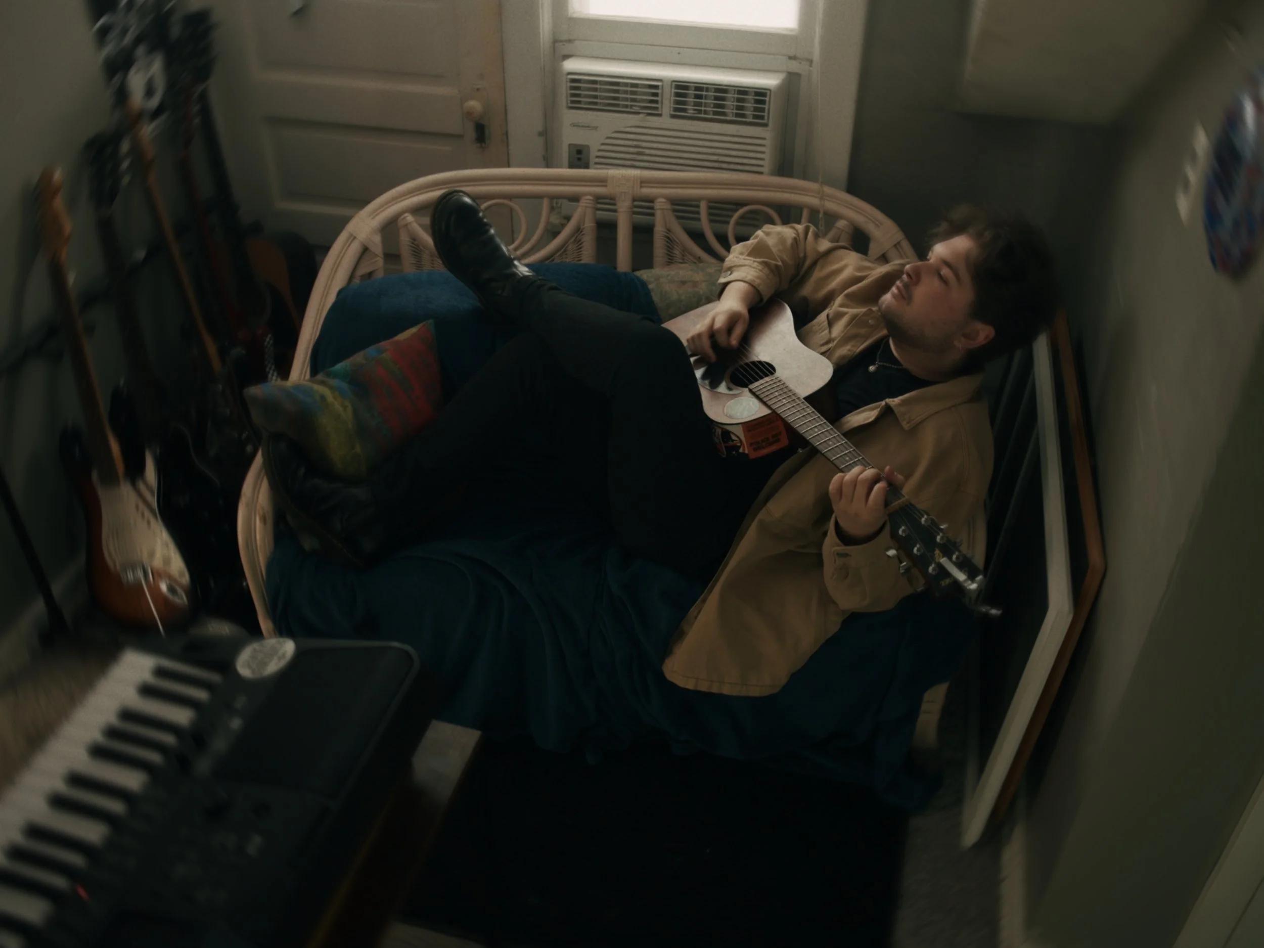 Tyler Armstrong of Scorched Waves laying down with guitar. 