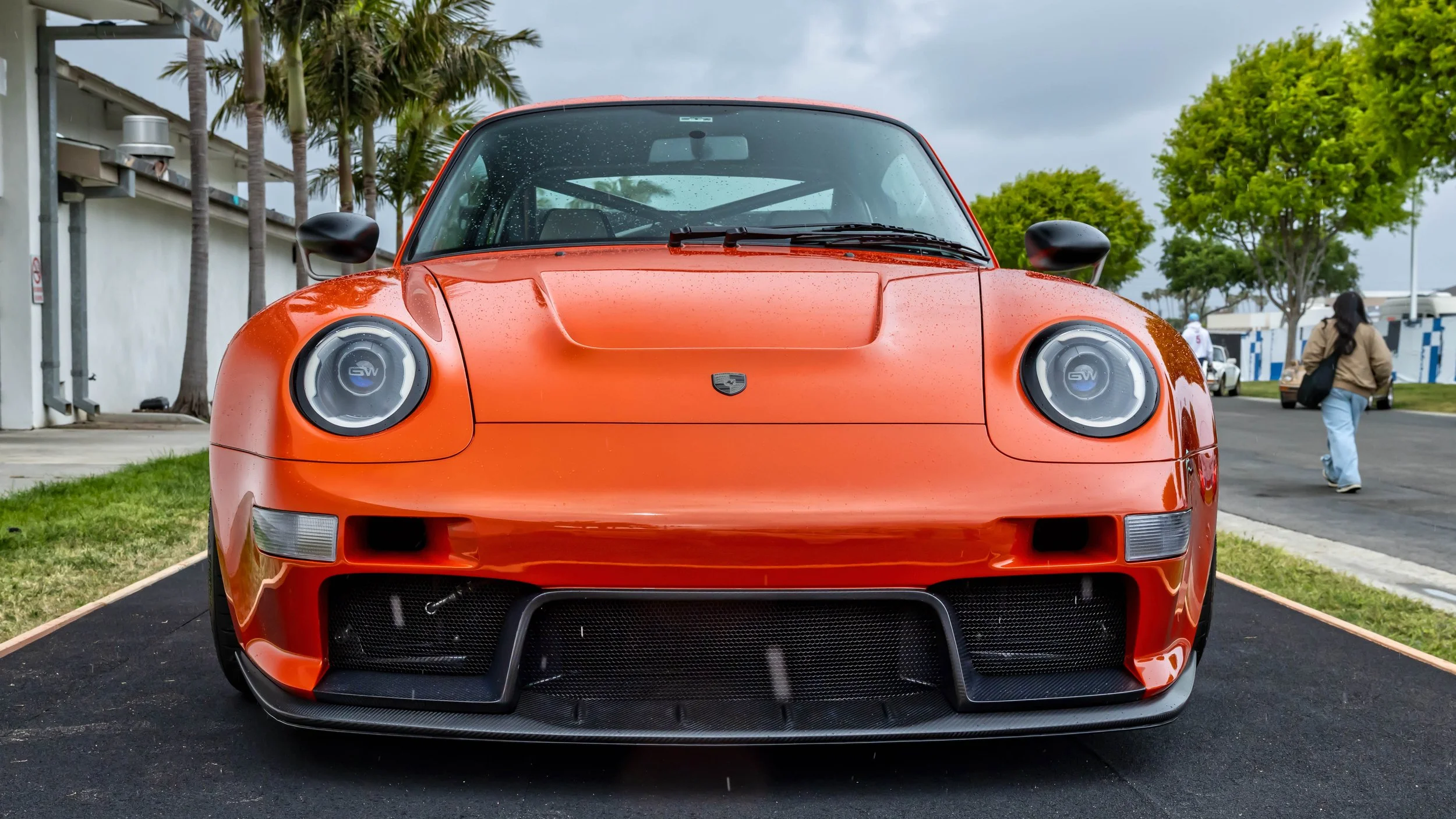Air | Water 2025 — Gunther Werks — Orange County Fairgrounds — A low-angle, head-on photograph of a Gunther Werks Turbo (Tornado), displayed outdoors on an overcast day. The car features wide fenders, a large front bumper with mesh grilles and a carb