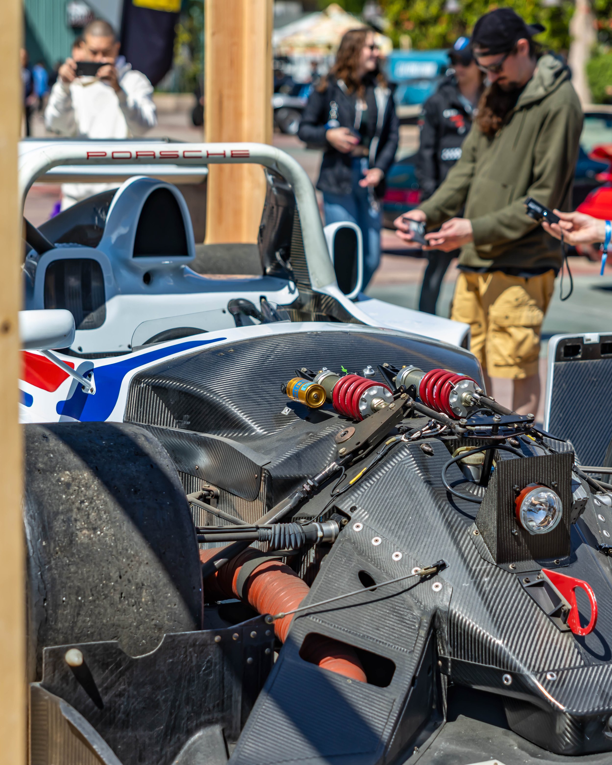 Air | Water 2025 — Orange County Fairgrounds — A detailed close-up of a No. 38 Lola B2K/10 race car race car with its front bodywork removed, revealing the intricate carbon-fiber chassis and pushrod suspension with Öhlins coilovers. The car, featurin