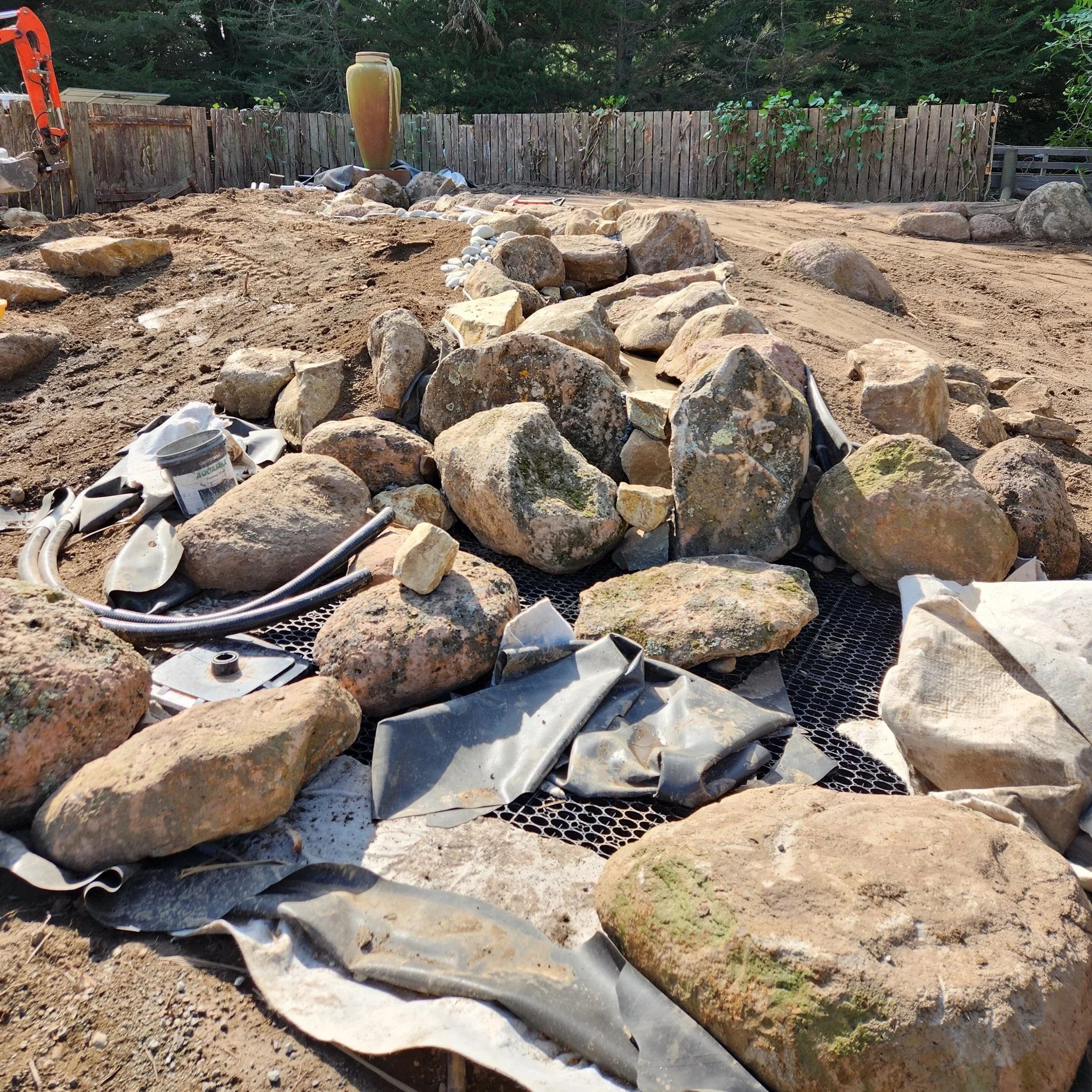 Pondless waterfall stream structure and pump pipework taking shape — Aylesbury build, Southern Waterscapes Ltd Selwyn