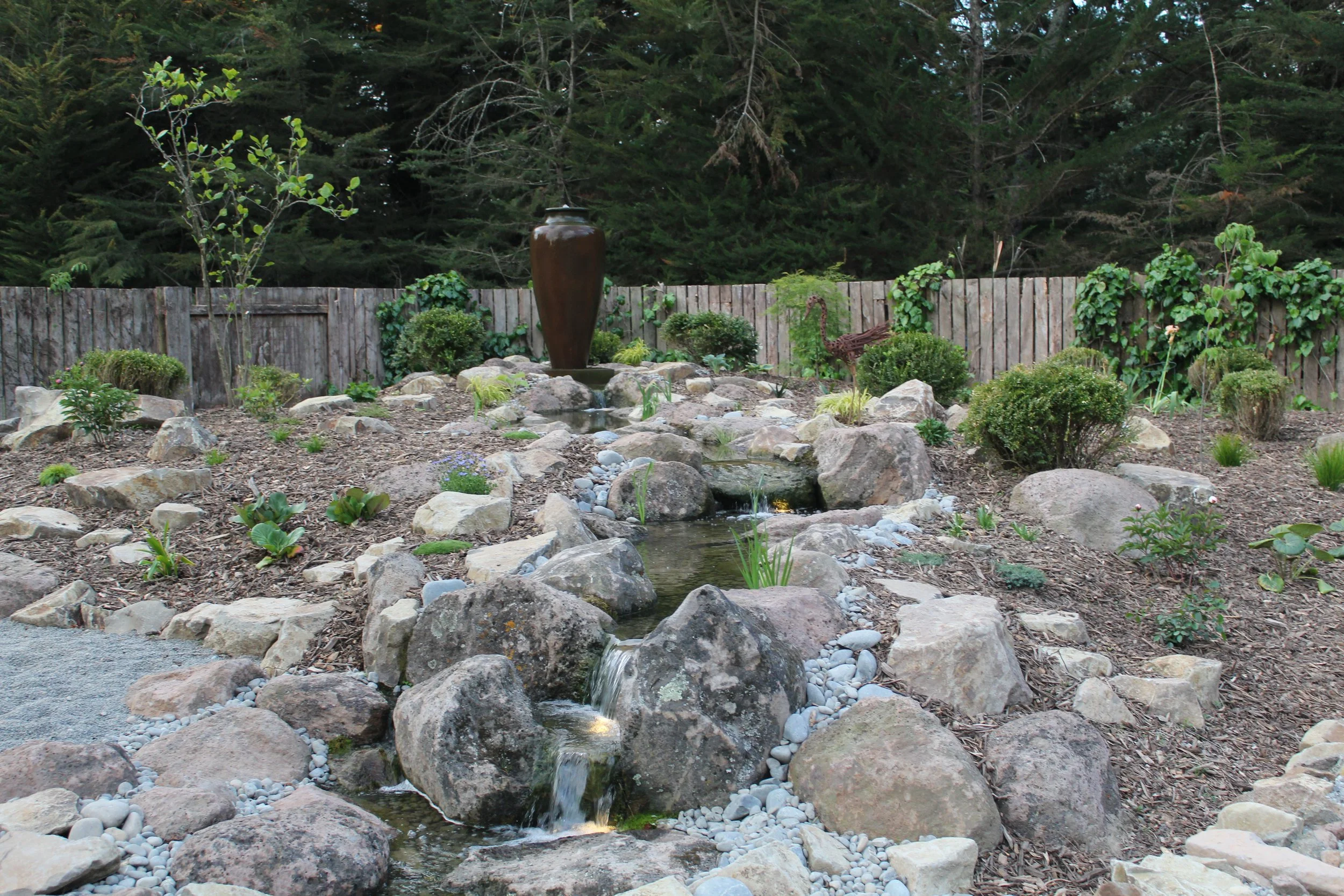 14-metre pondless waterfall with Oxford boulder placement and decorative urn, Aylesbury, Selwyn — Southern Waterscapes Ltd