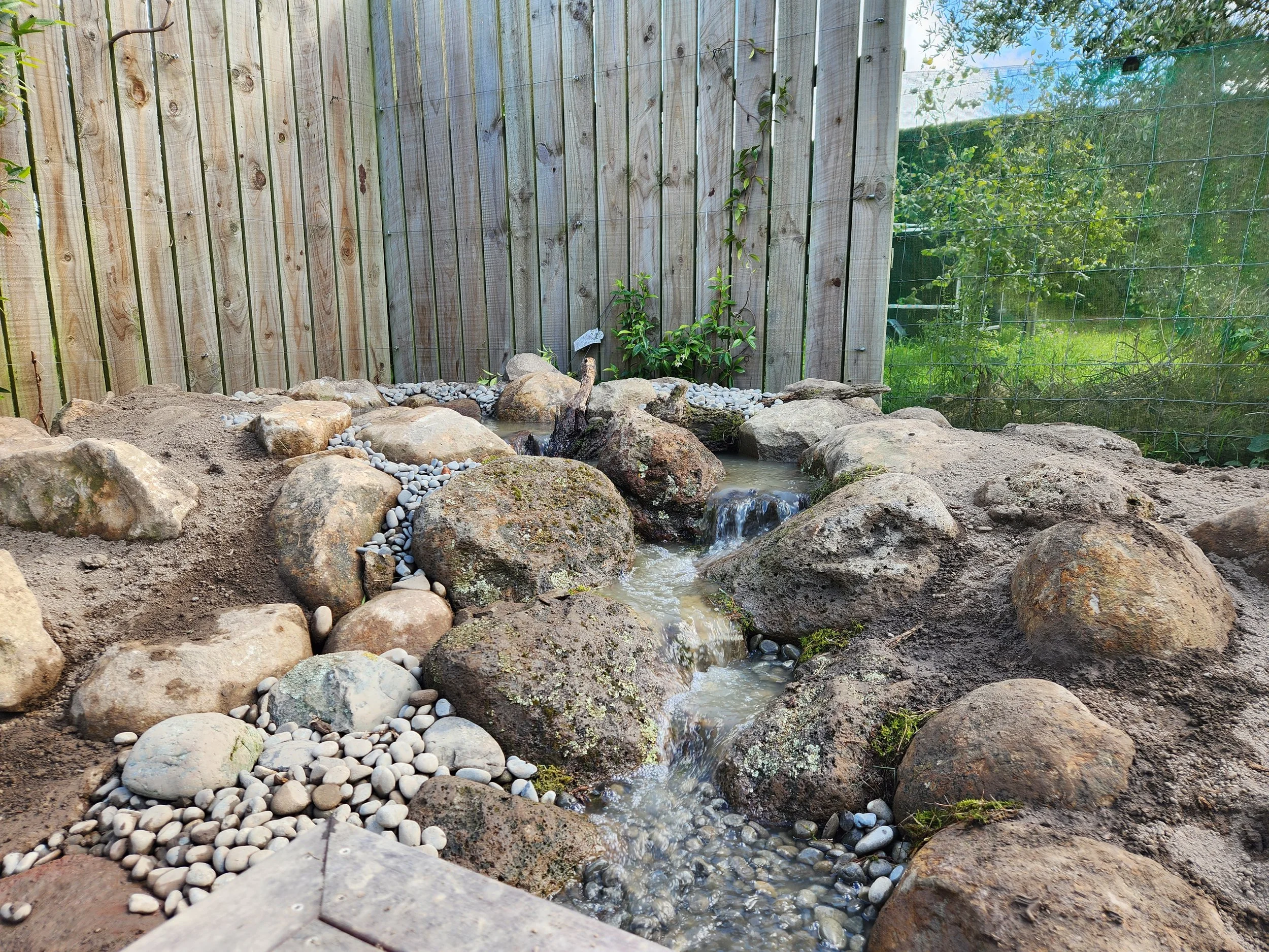Residential pondless waterfall with natural stone in Canterbury garden — Southern Waterscapes Ltd
