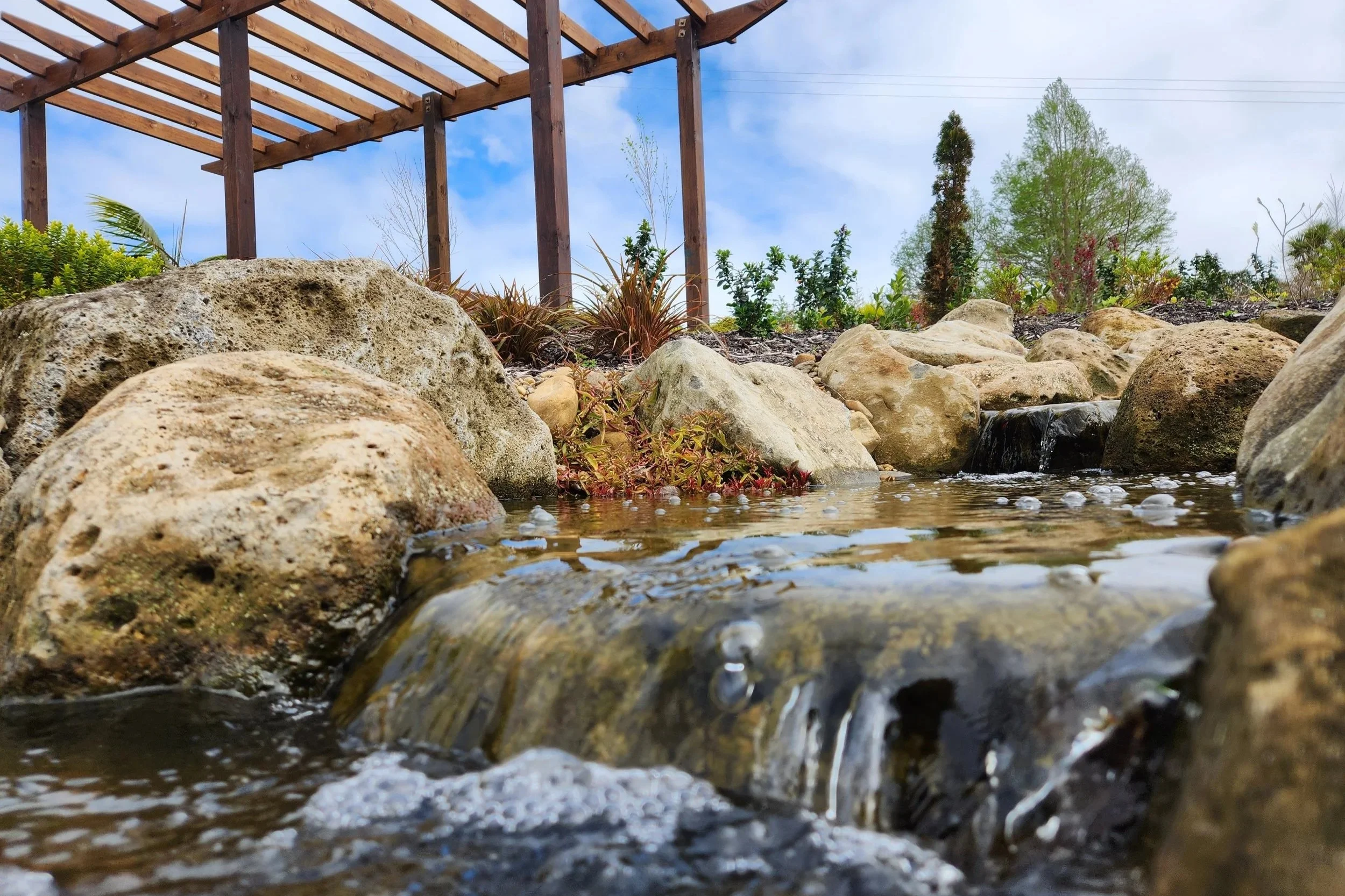 Ecosystem pond waterfall inlet with Northland field boulder, Dairy Flat, Auckland — Southern Waterscapes Ltd