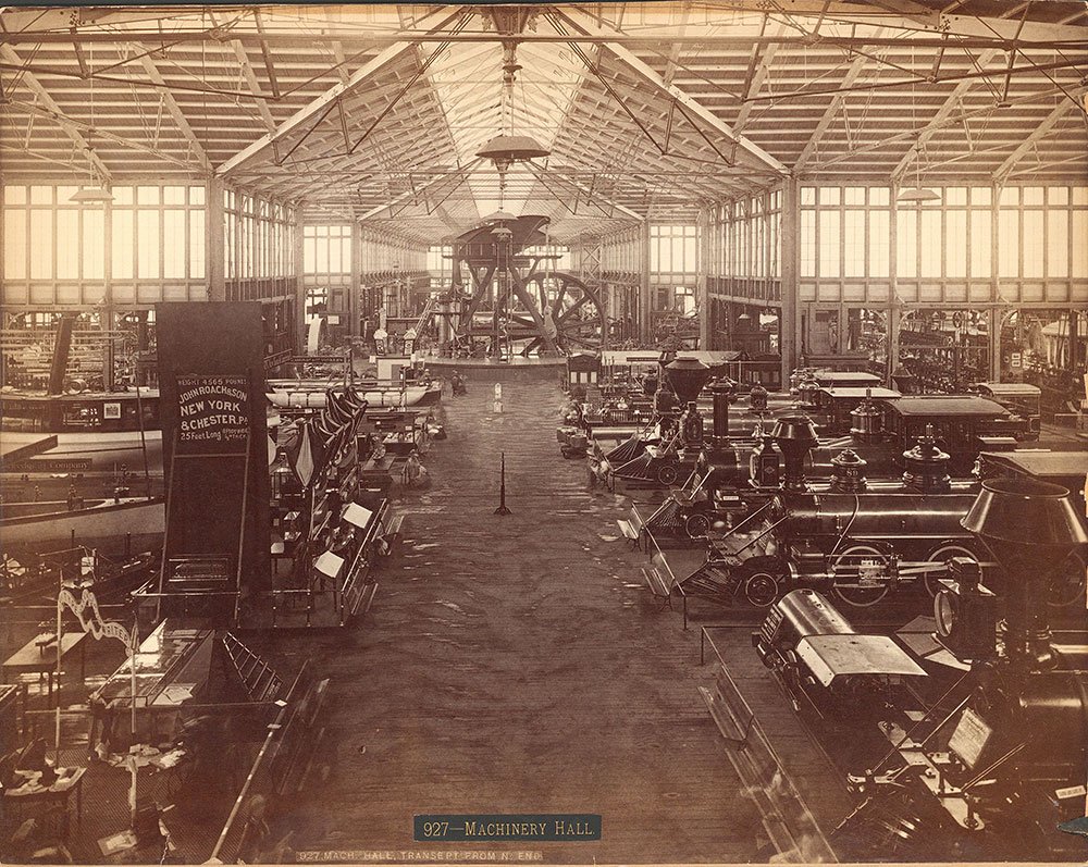 View of Machinery Hall. Waltham's exhibit can be seen with a small booth with 3 white windows at the base of the Corliss engine (public domain, Centennial Photographic Company)