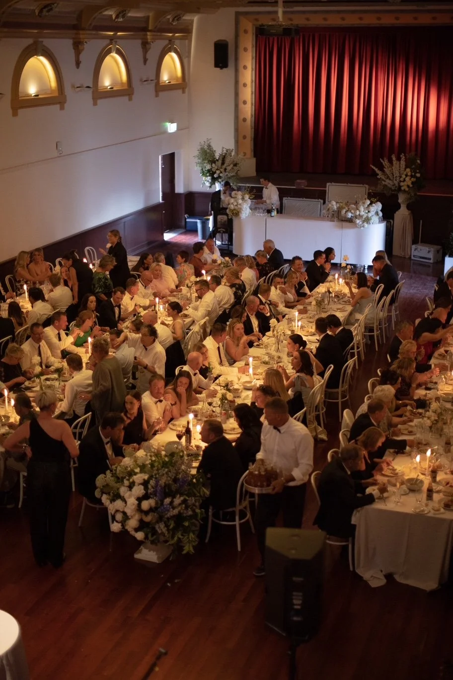 Guests dining by candlelight at Lily and Jayden’s Deniliquin Town Hall wedding reception.