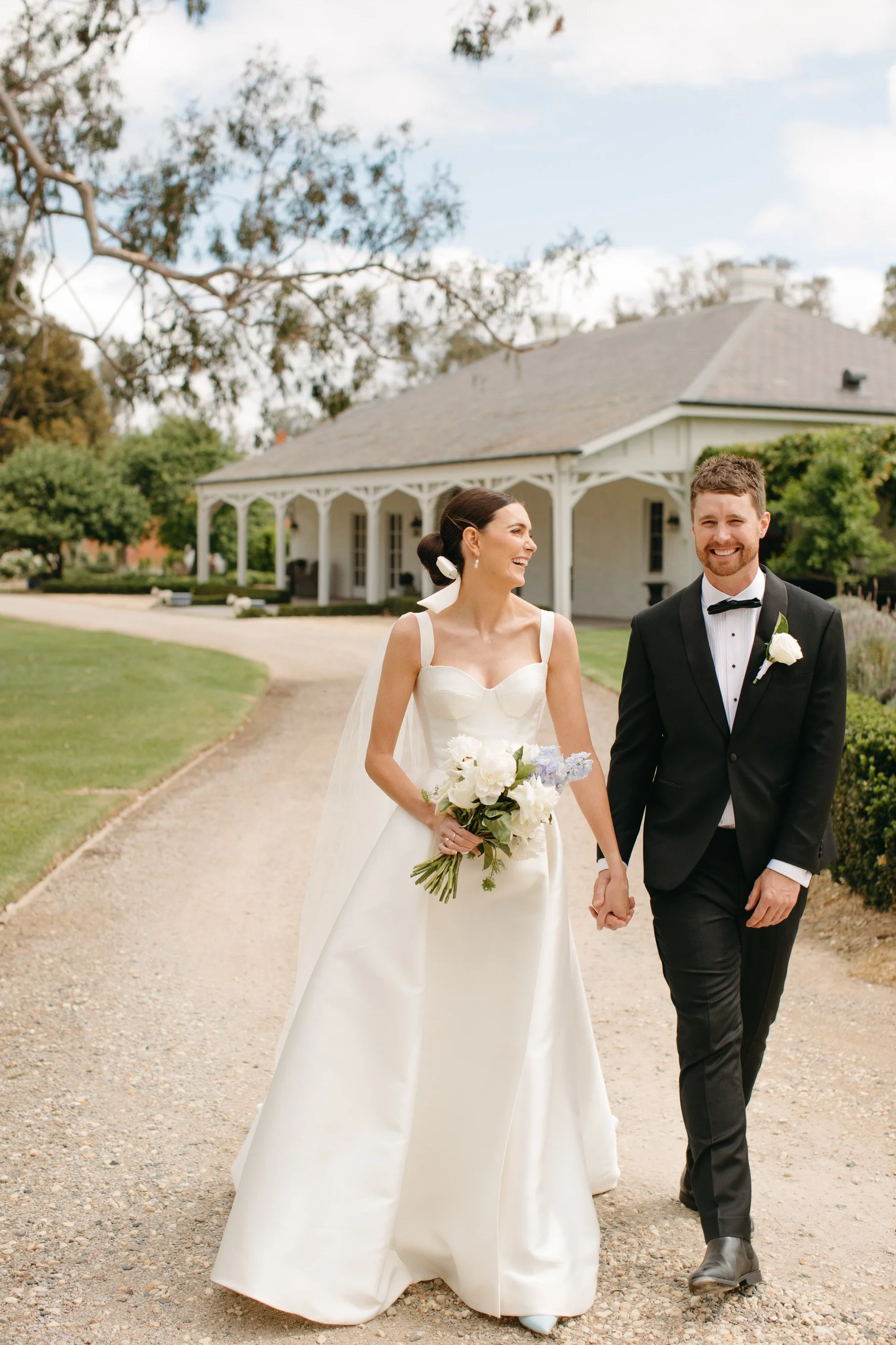 Lily and Jayden walking together at Mundiwa Homestead on their wedding day.
